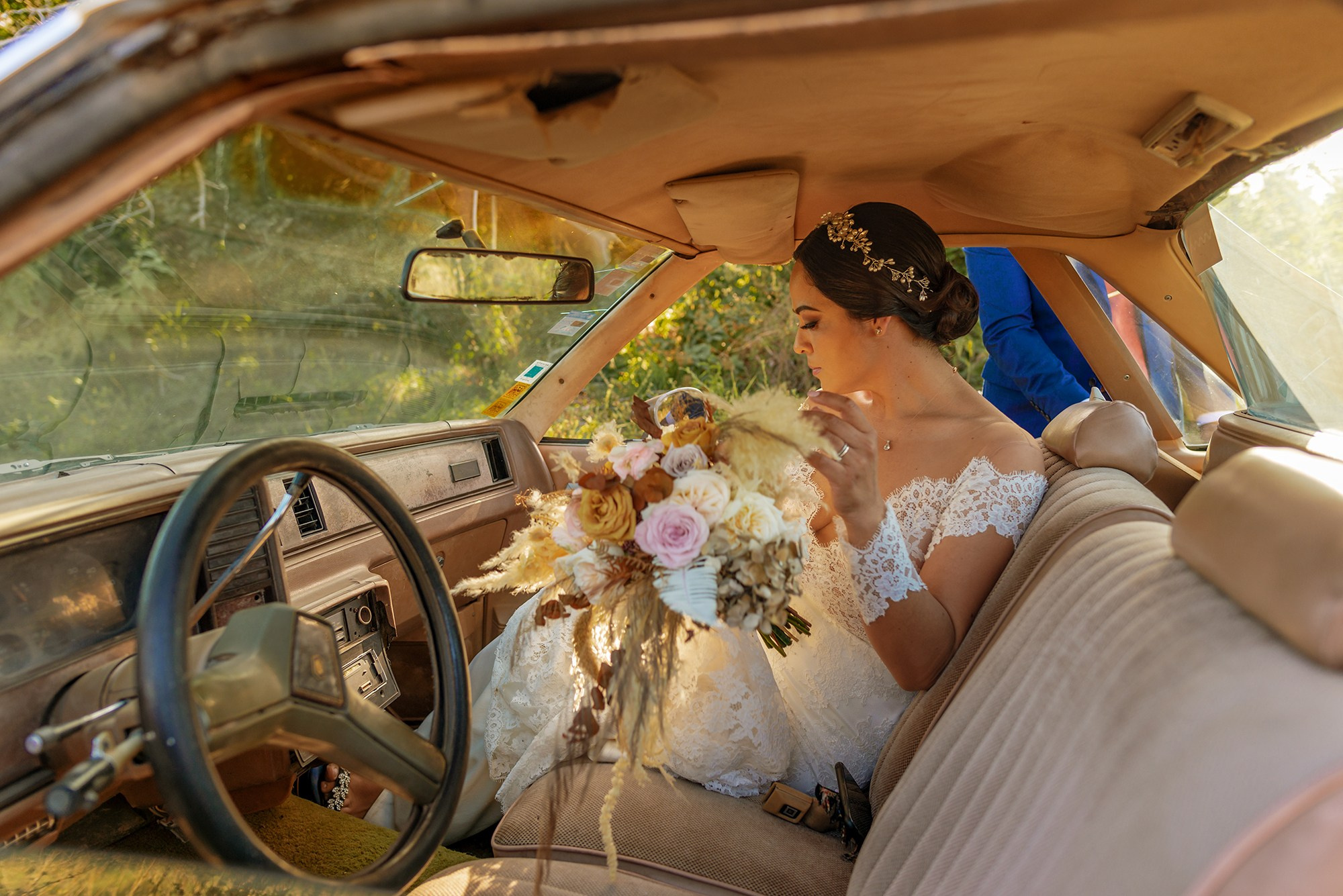 Bride arriving to wedding with bouquet detail inside car in Los Cabos