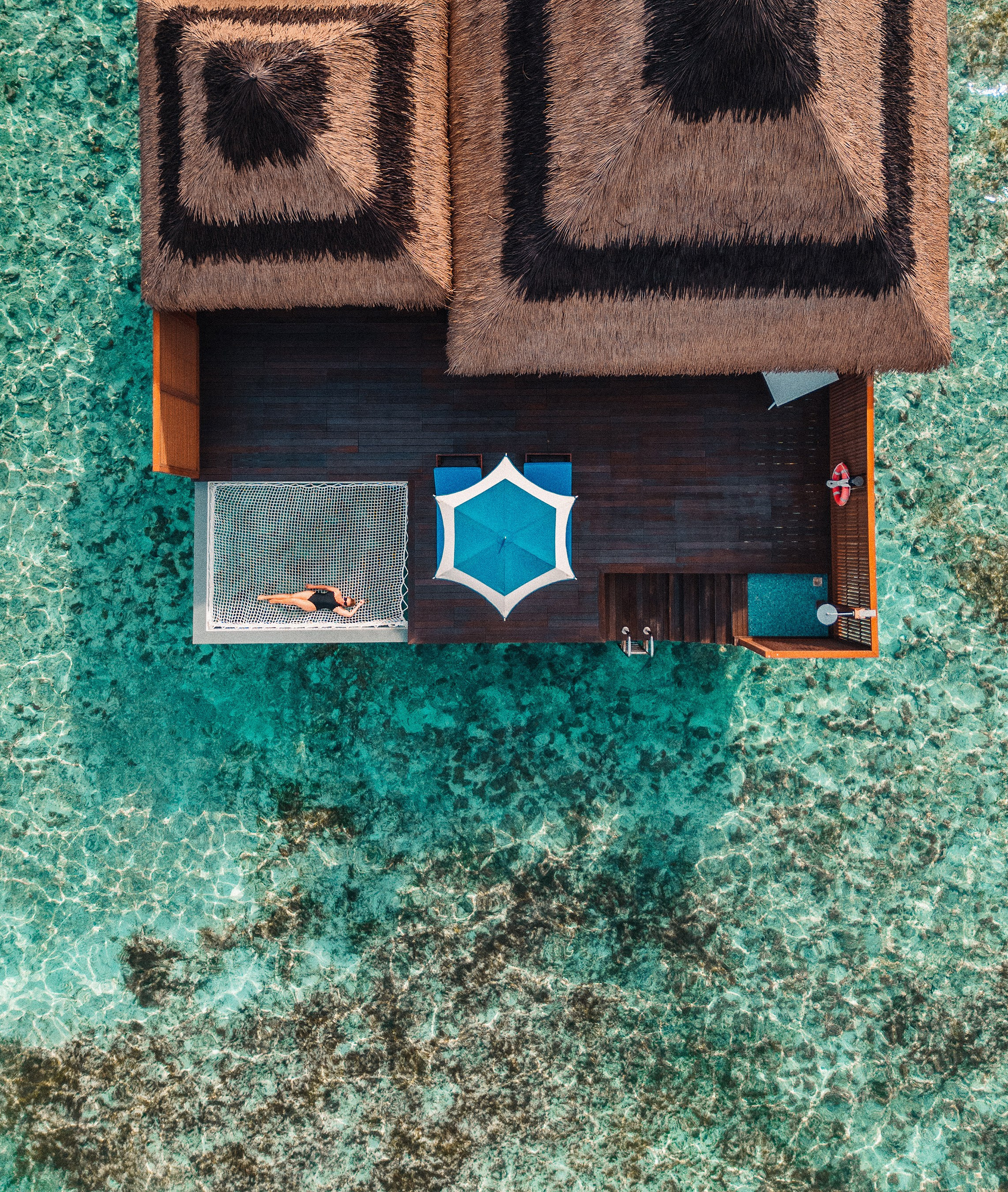 Beachwear lifestyle photography featuring a model in a tropical resort setting using drone