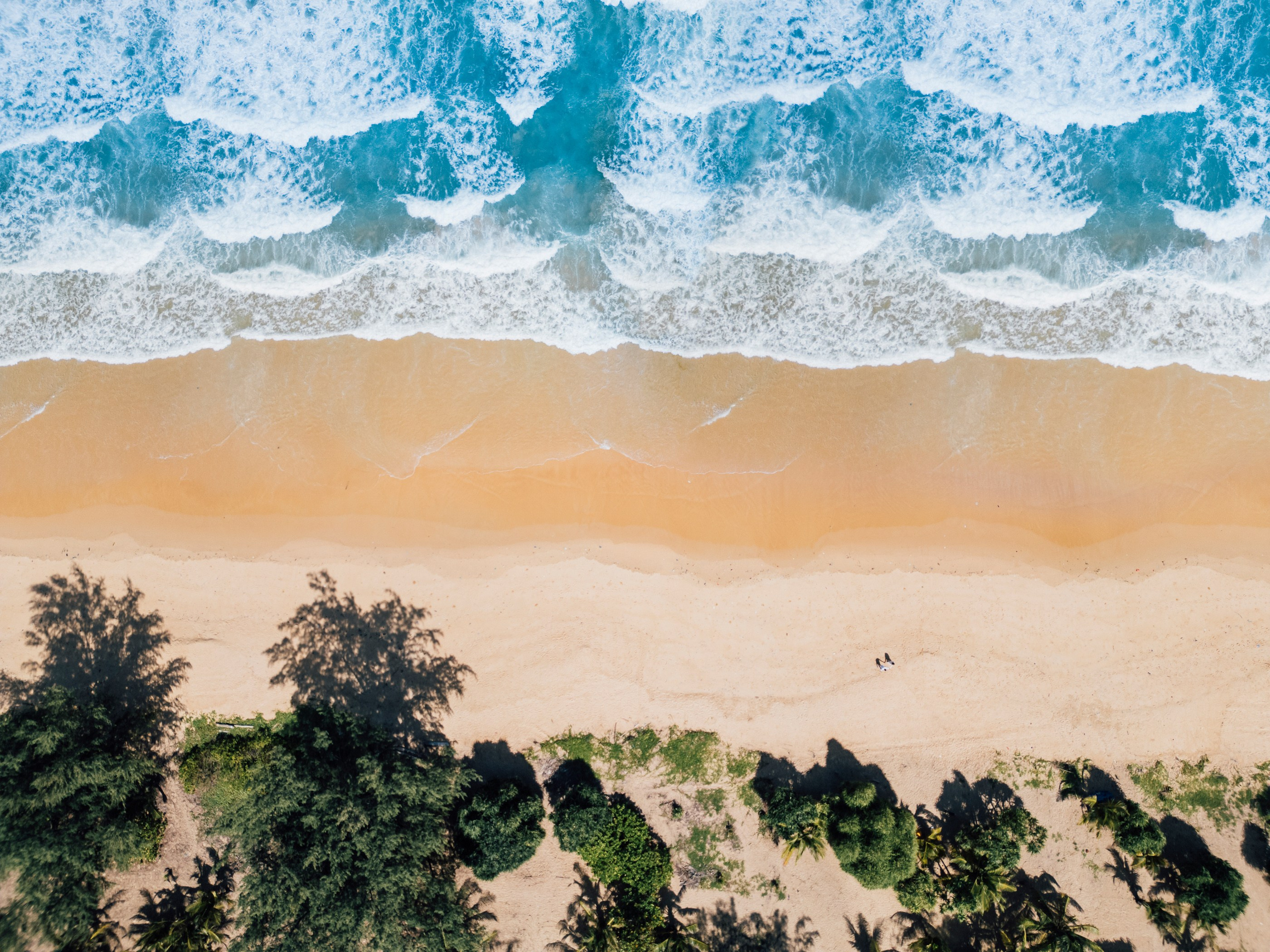 Aerial photography in Phuket featuring a tropical beach, turquoise sea and dramatic island landscape