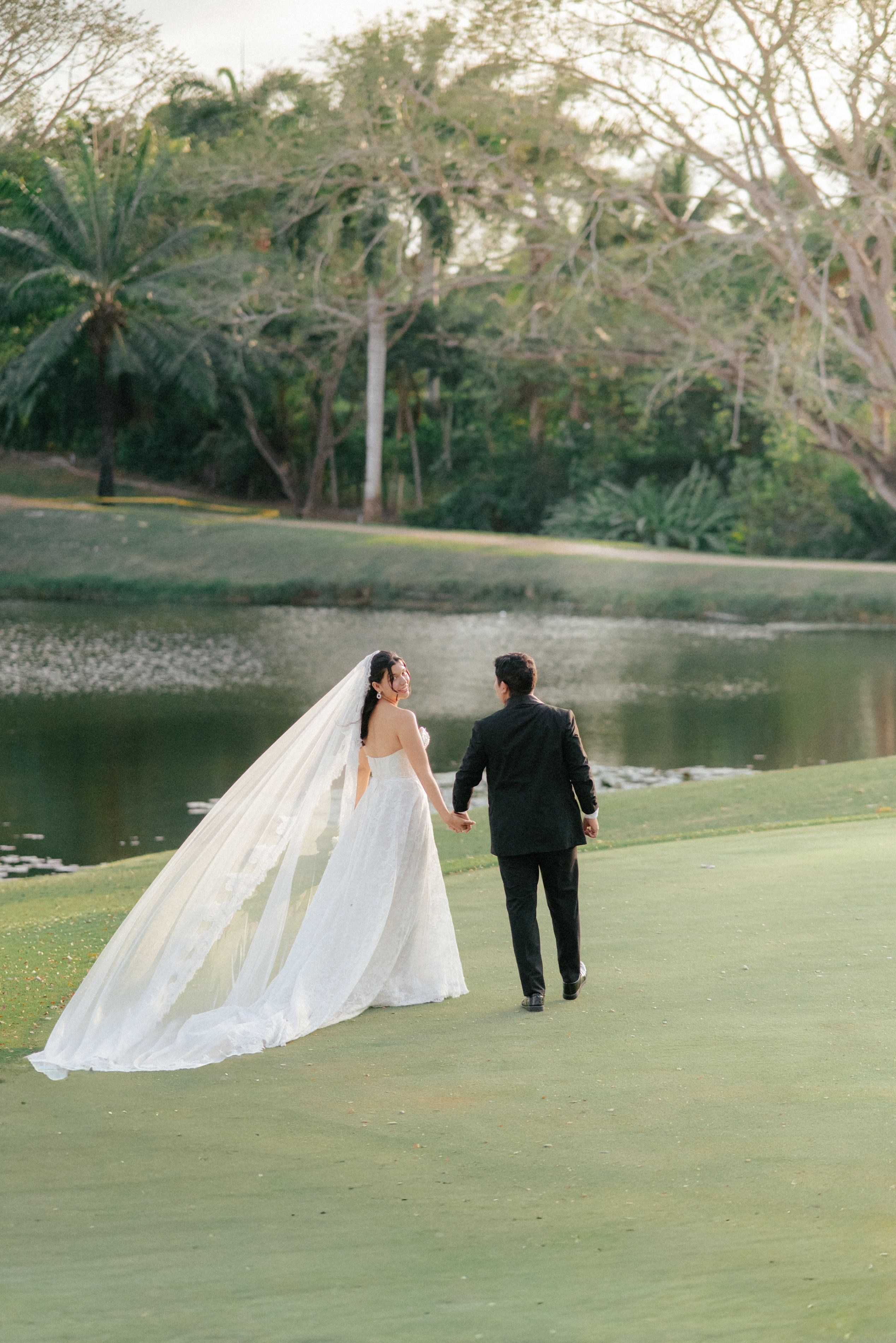 Bride and groom walking in garden – “Bride and groom walking together through lush garden scenery, high-quality wedding photoshoot in Cartagena