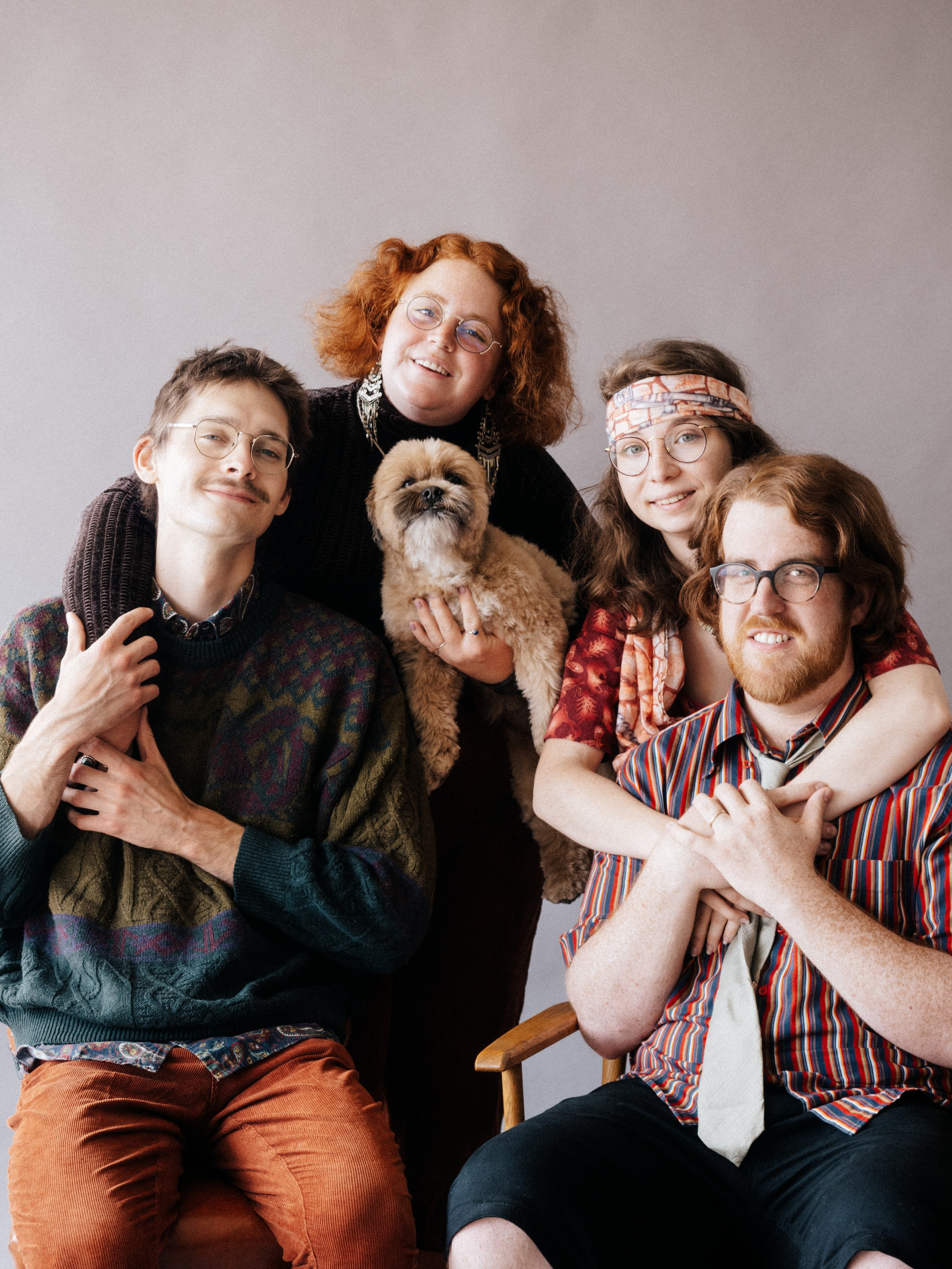 Young family - brother and sister and spouses - in studio on brown background.