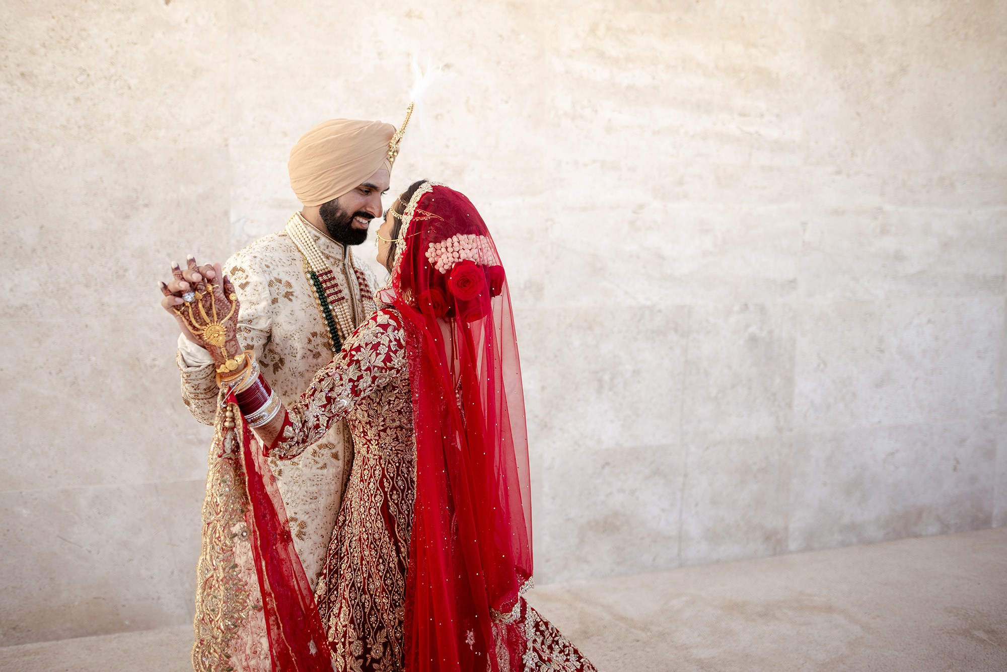 Indian bride and groom in traditional attire dancing during destination wedding at Los Cabos resort