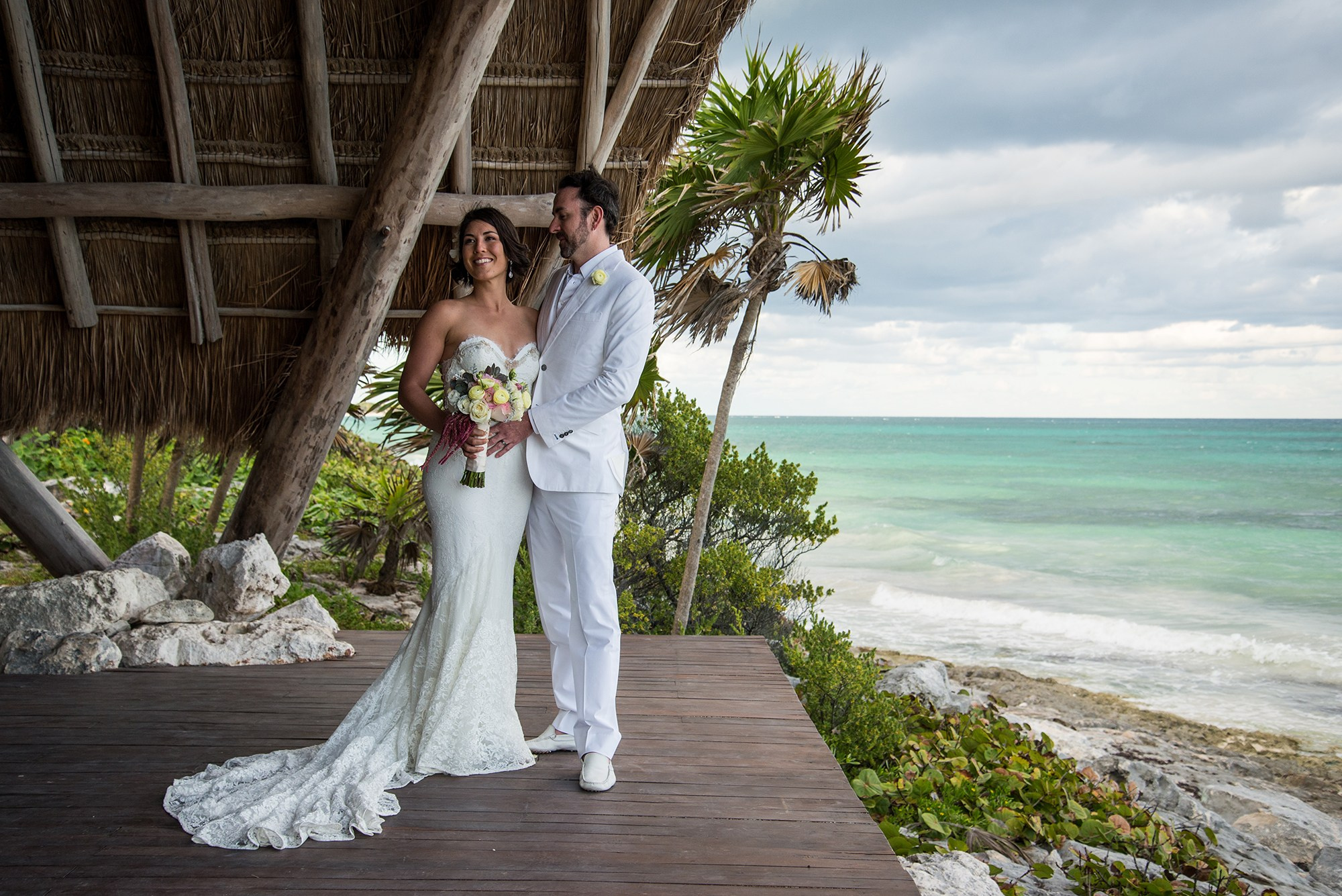 Groom looking at bride during post-ceremony portrait at sunset in Tulum, Mexico