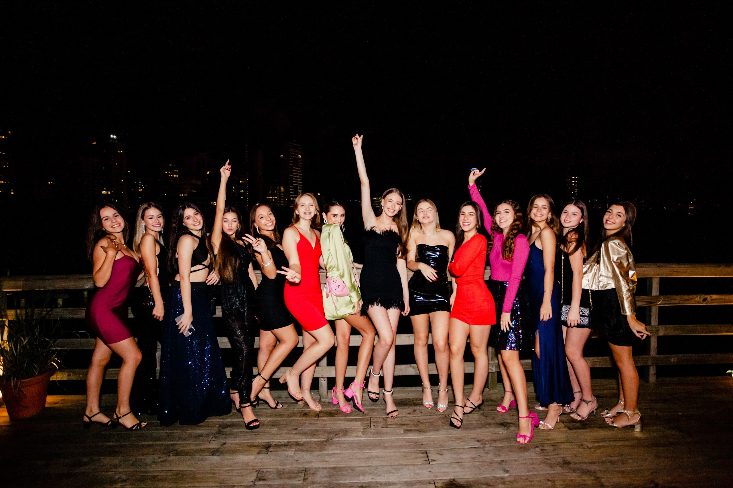 Fotógrafo festa de aniversário em Itajaí; retrato em grupo animado da aniversariante a celebrar com todas as amigas numa festa noturna ao ar livre.