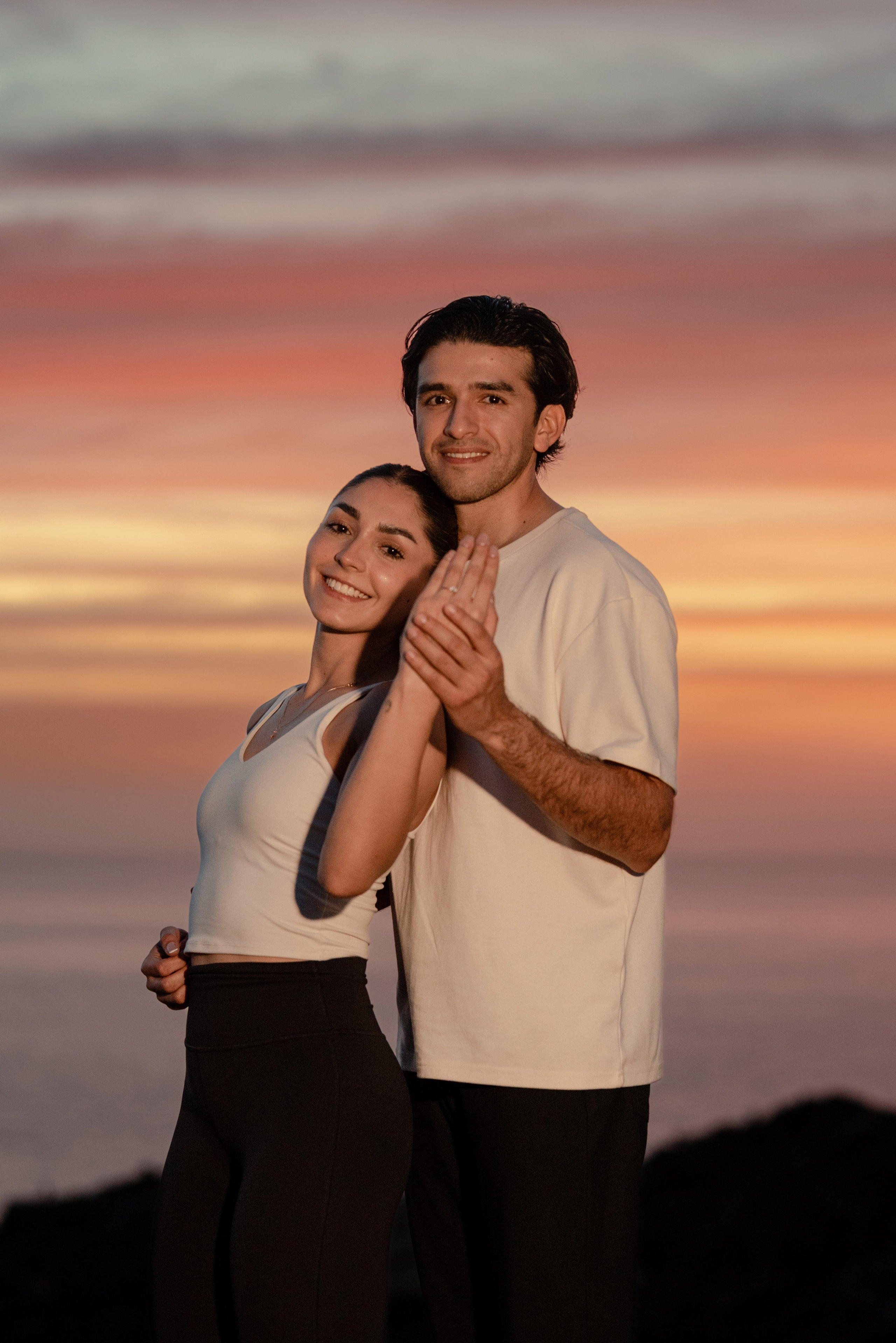 Intimate couple portrait at golden hour on Punta Lobos cliffs overlooking Pacific Ocean, Todos Santos