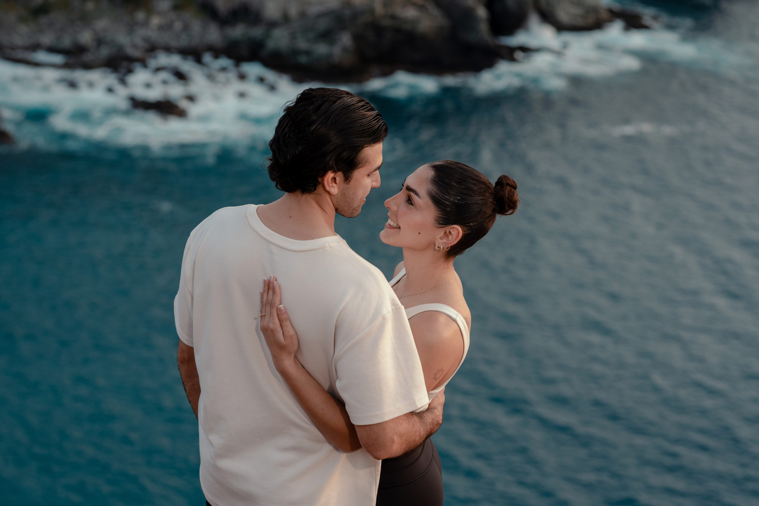 Intimate couple portrait face to face with turquoise Pacific Ocean backdrop during engagement session at Punta Lobos, Todos Santos Mexico