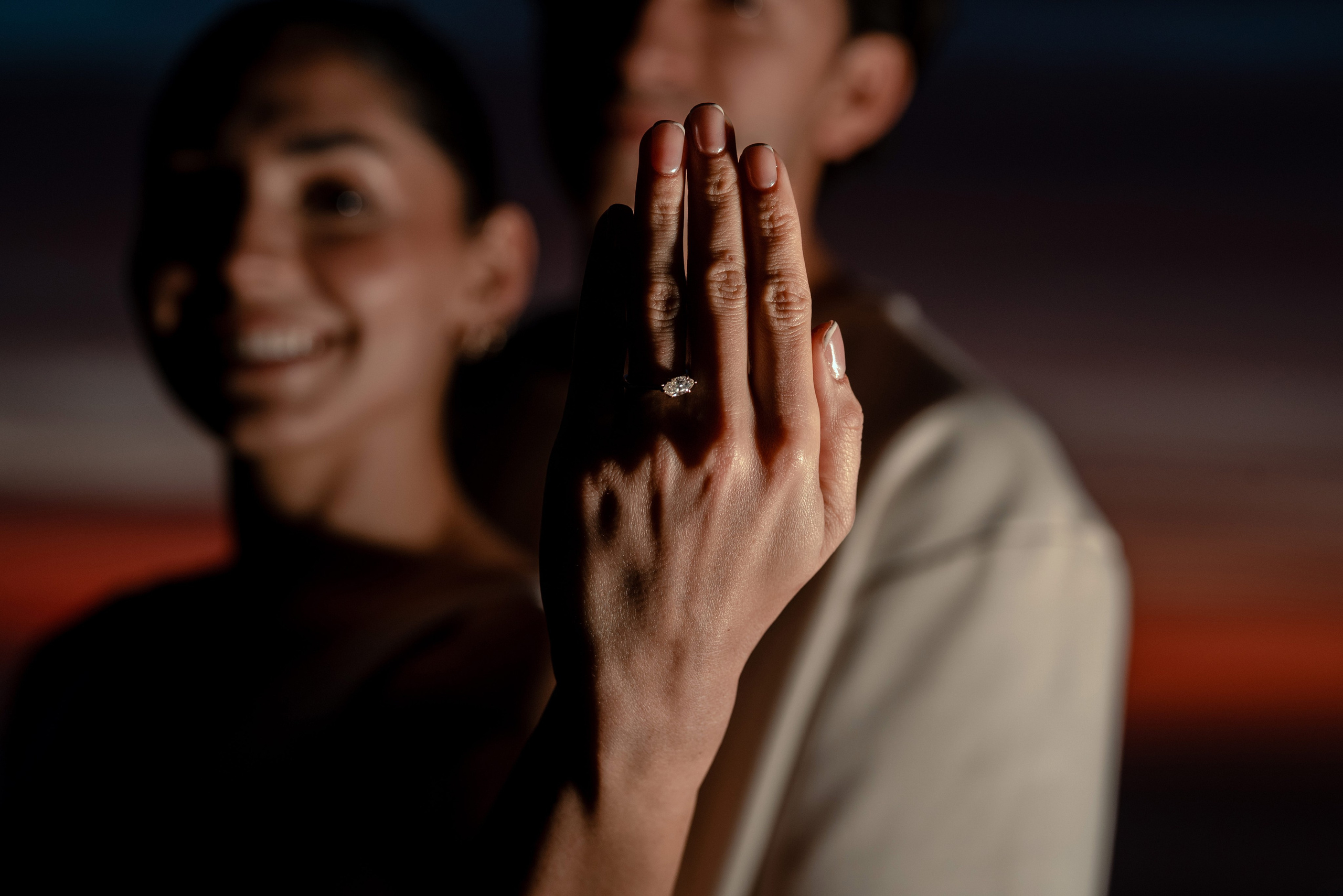 Close-up engagement portrait showing ring at golden hour on Punta Lobos cliffs, Todos Santos Mexico