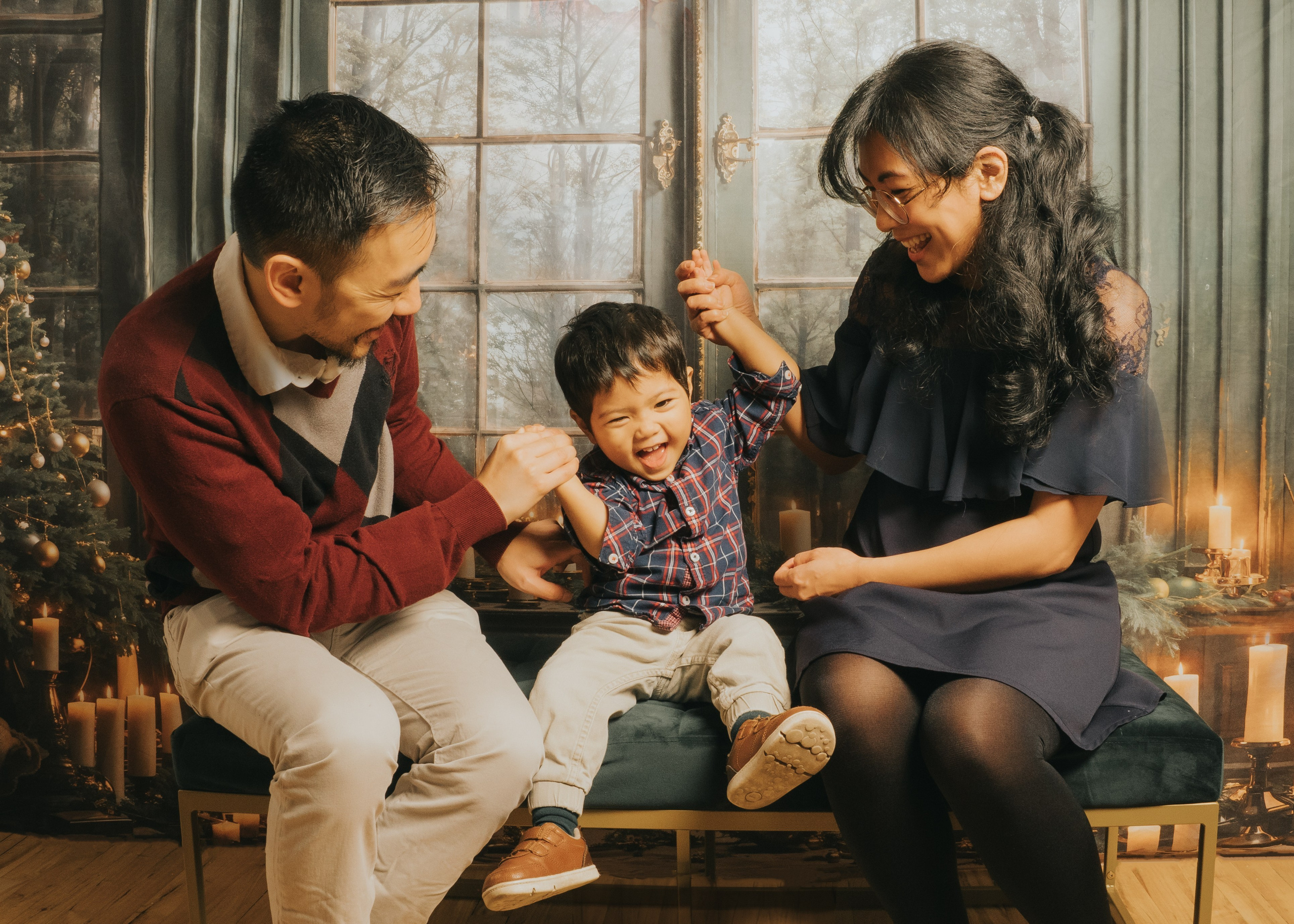 Parents tickling small child.