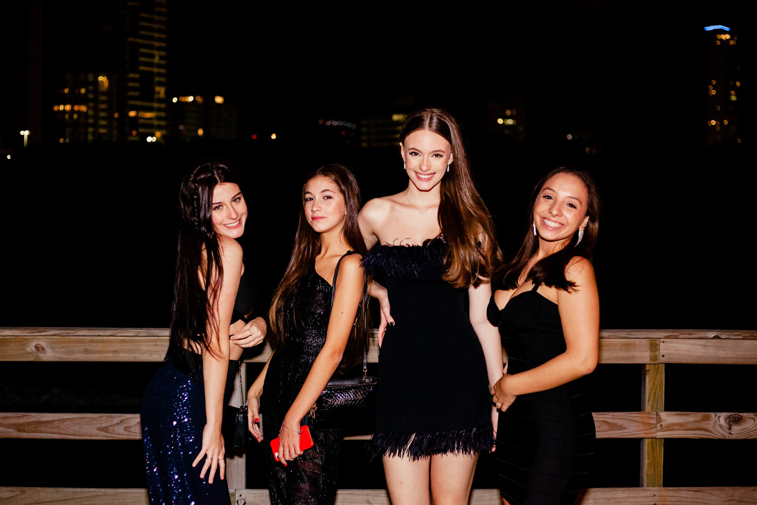 Fotógrafo festa de aniversário em Itajaí; retrato em grupo da aniversariante sorridente ao lado de suas amigas em evento festivo noturno.