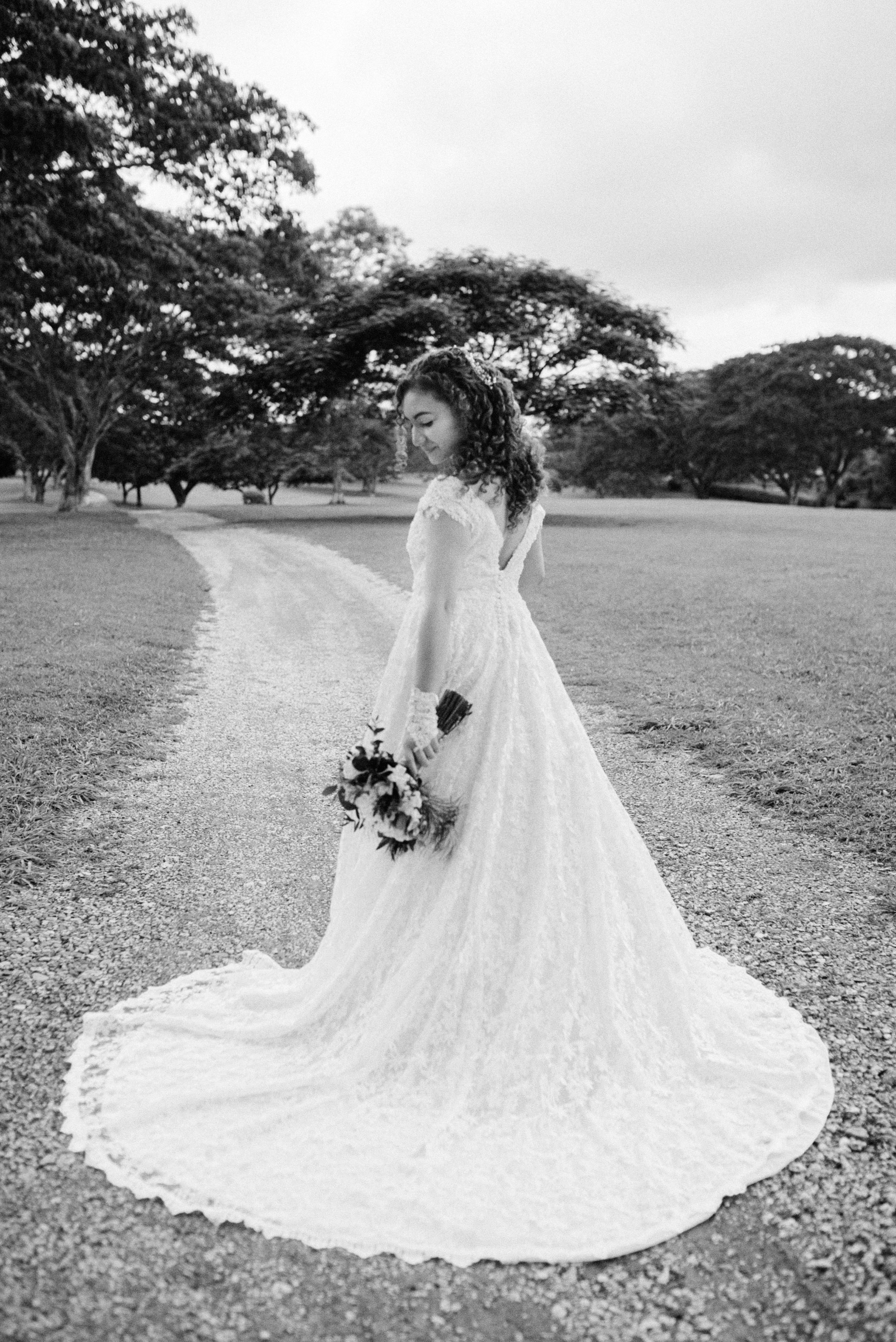 Bride walking alone – “Bride walking alone in her wedding dress on a scenic path, elegant wedding photography in Cartagena