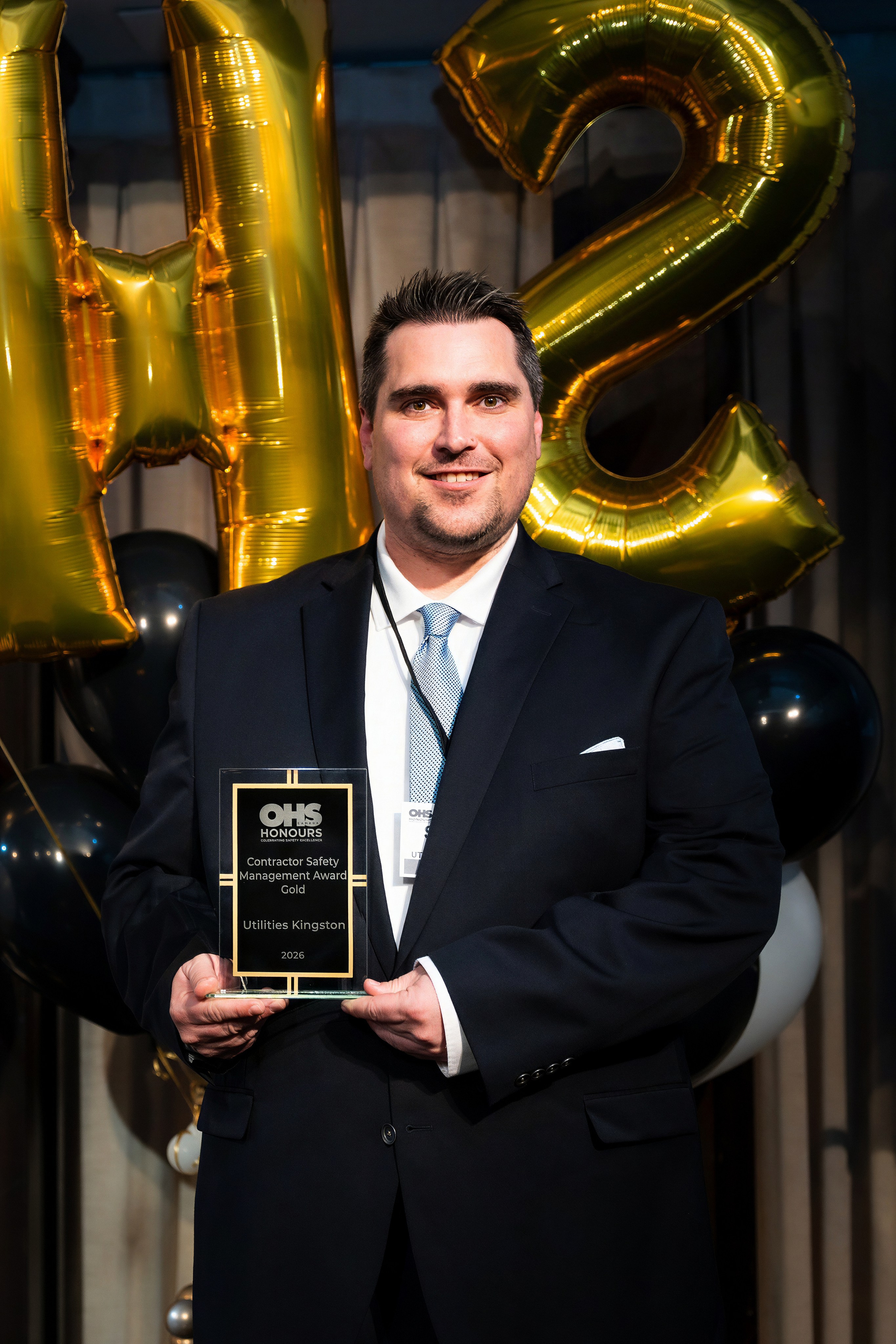 Young safety professional holding an award at OHS Honours 2026