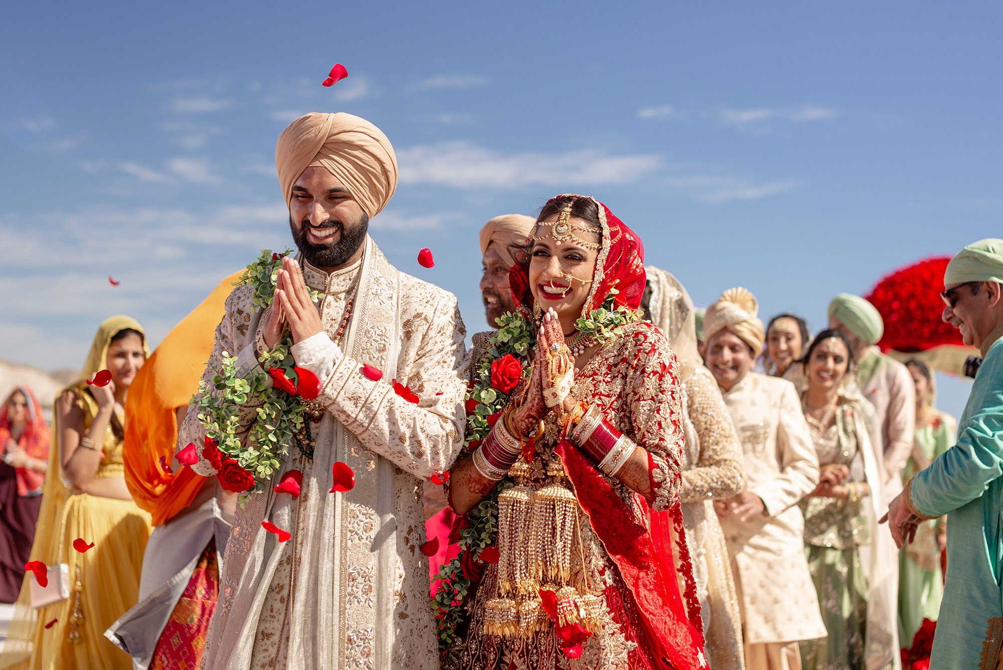 Bride and groom greeting guests with namaste during Indian wedding ceremony in Los Cabos, Baja California Sur