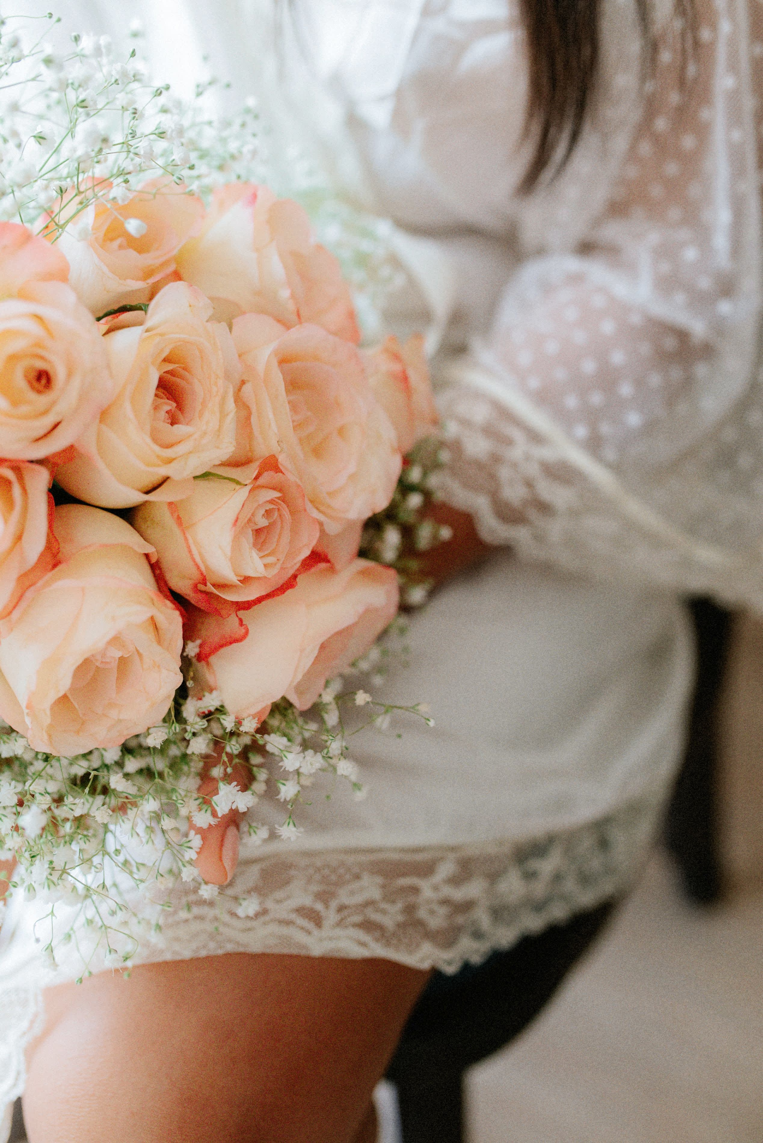 Close-up of bride holding a peach-colored wedding bouquet in Cartagena, destination wedding details
