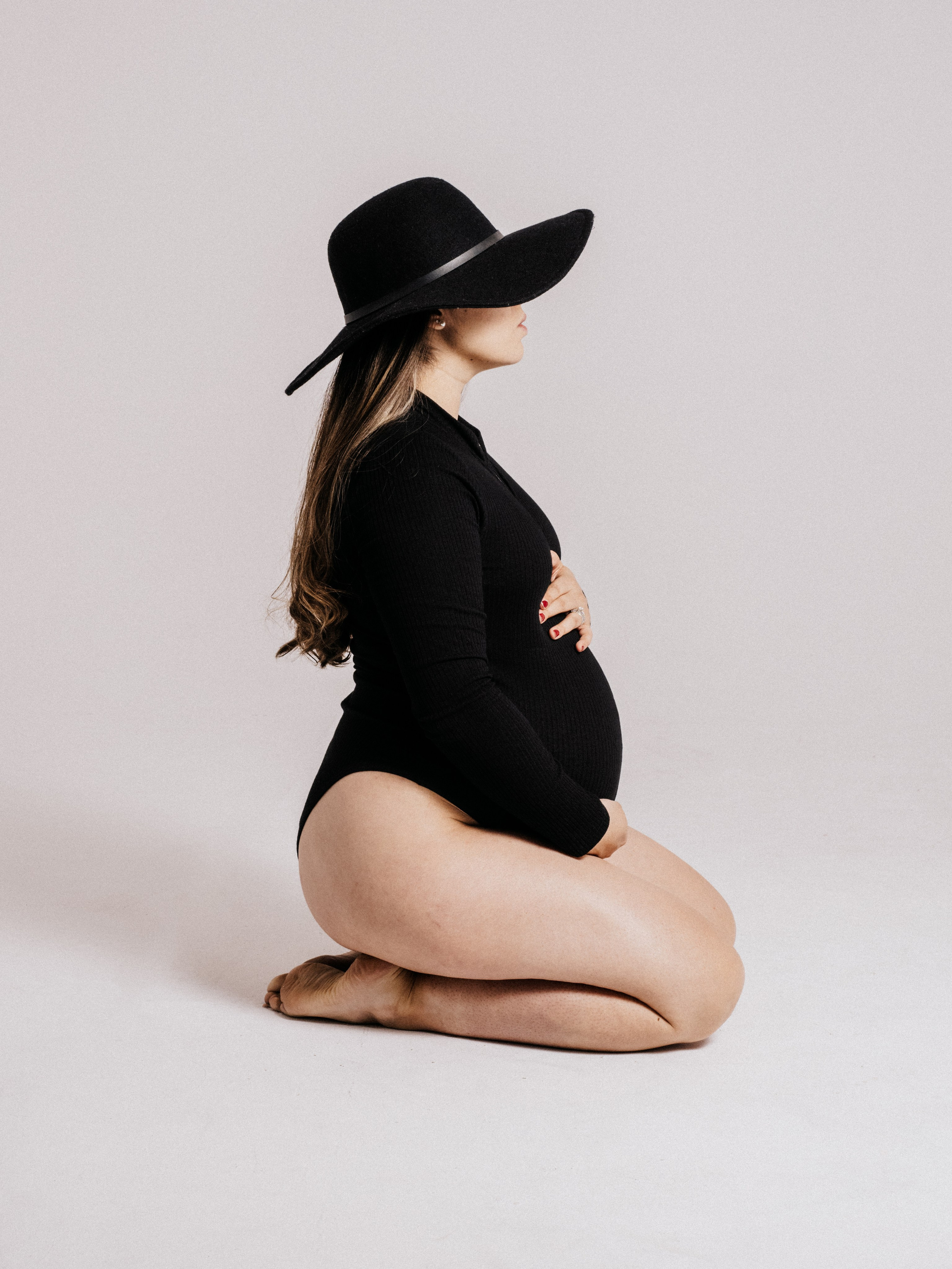 Pregnant woman kneeling in a Montreal studio.