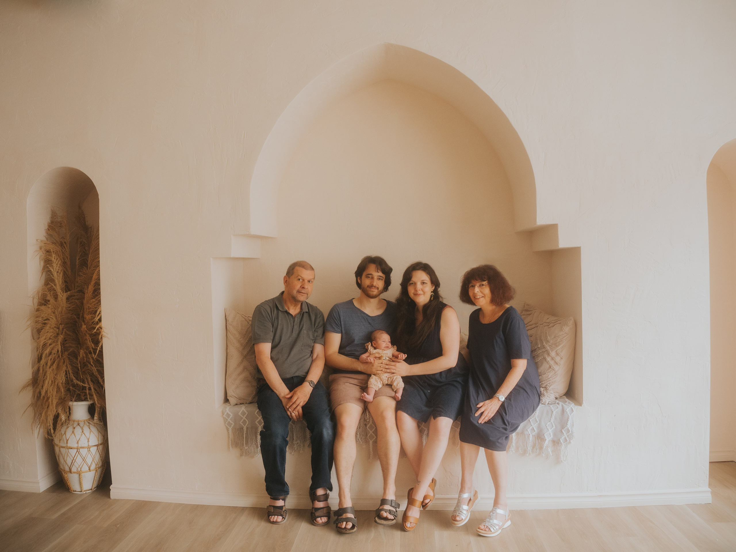Three generations family in studio surrounded by arch.