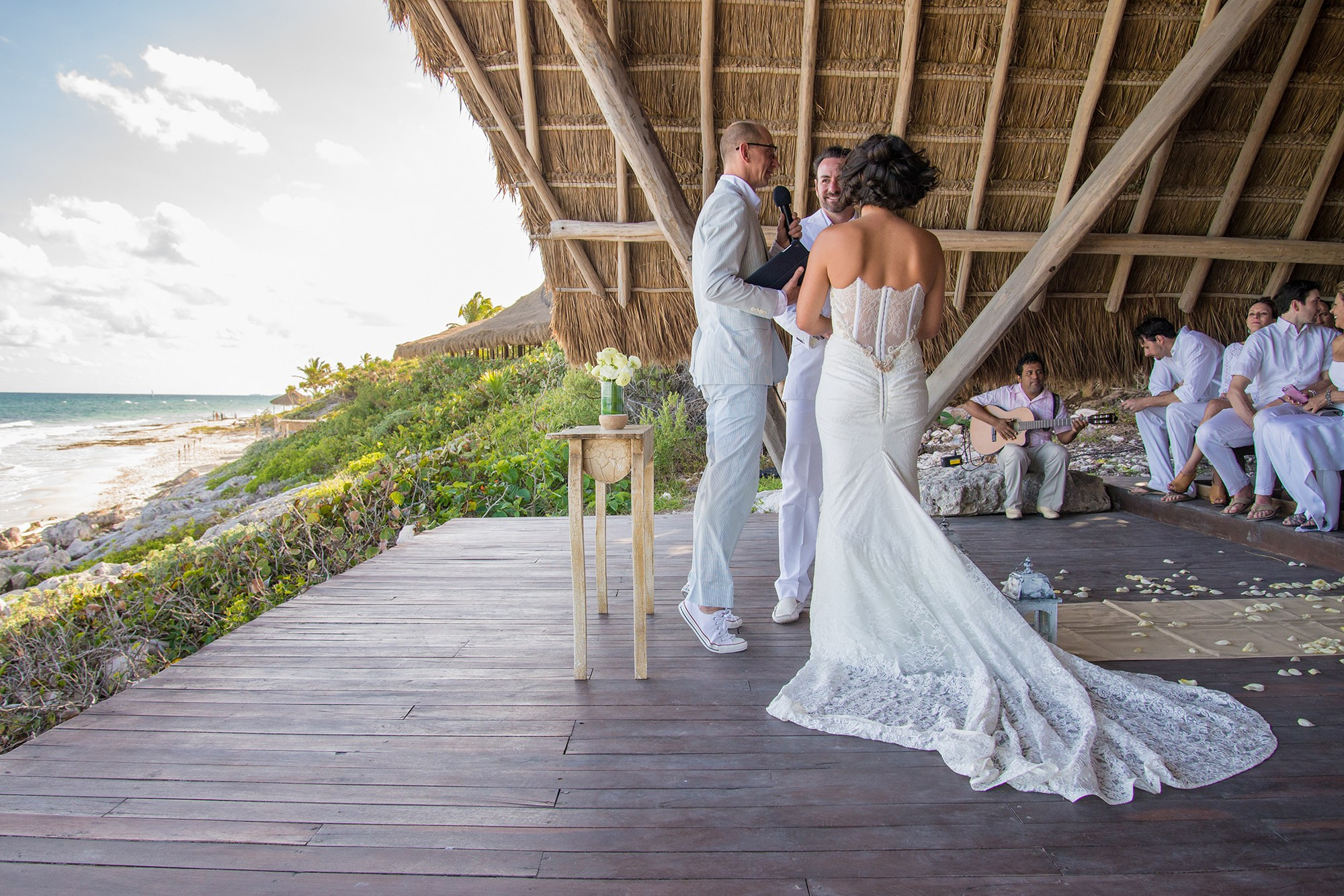 Bride's gown flowing during oceanfront wedding celebration in Cancun Area