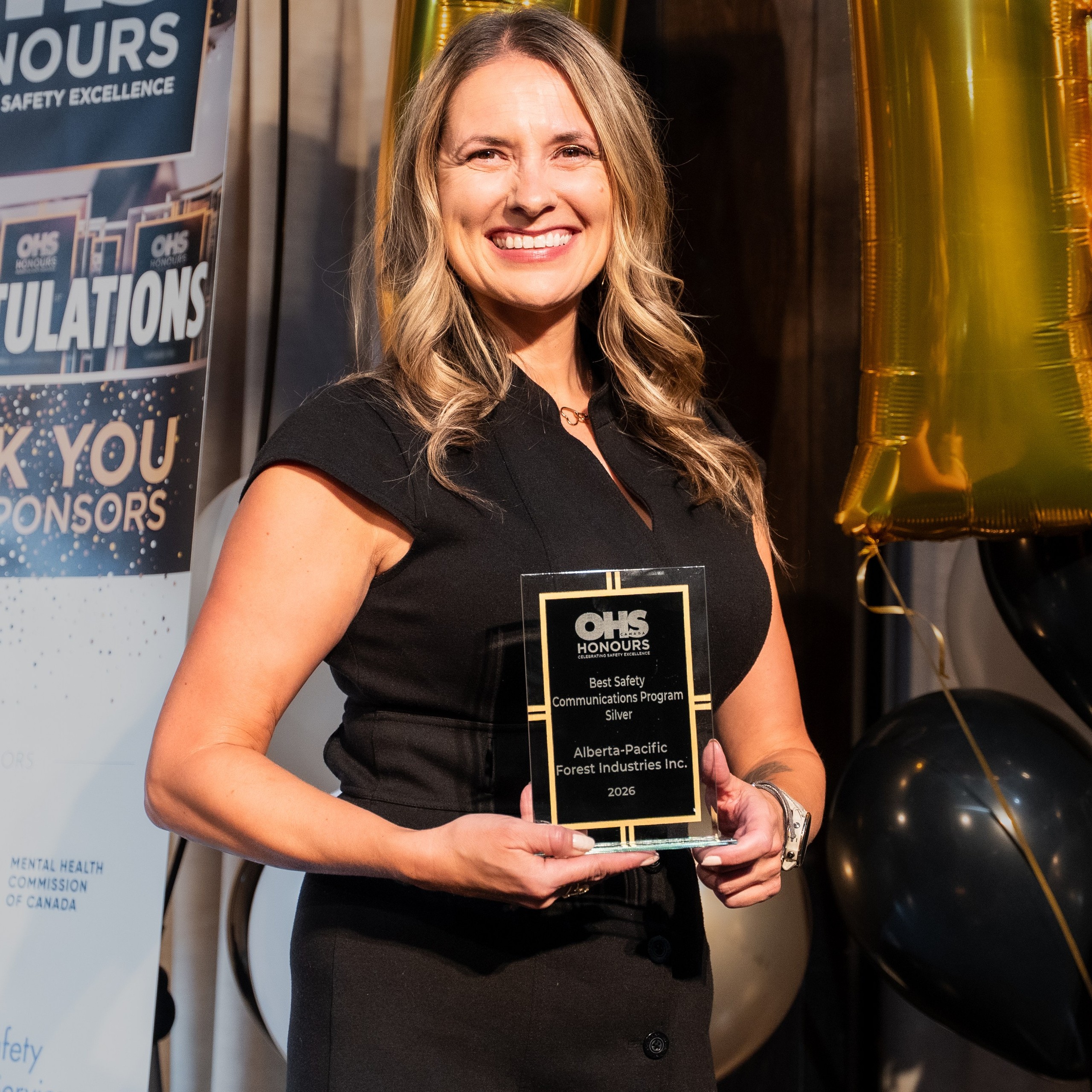 Female award recipient holding an OHS Honours trophy in Toronto