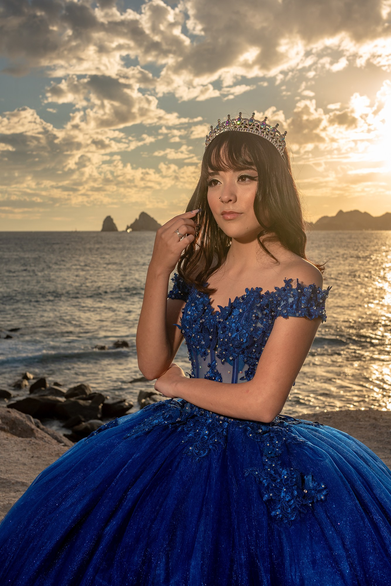 XV años photoshoot in Cabo – Quinceañera Michelle posing in blue embroidered dress with colorful bouquet, portrait photography for sweet fifteen celebrations in Los Cabos at the beach during sunset