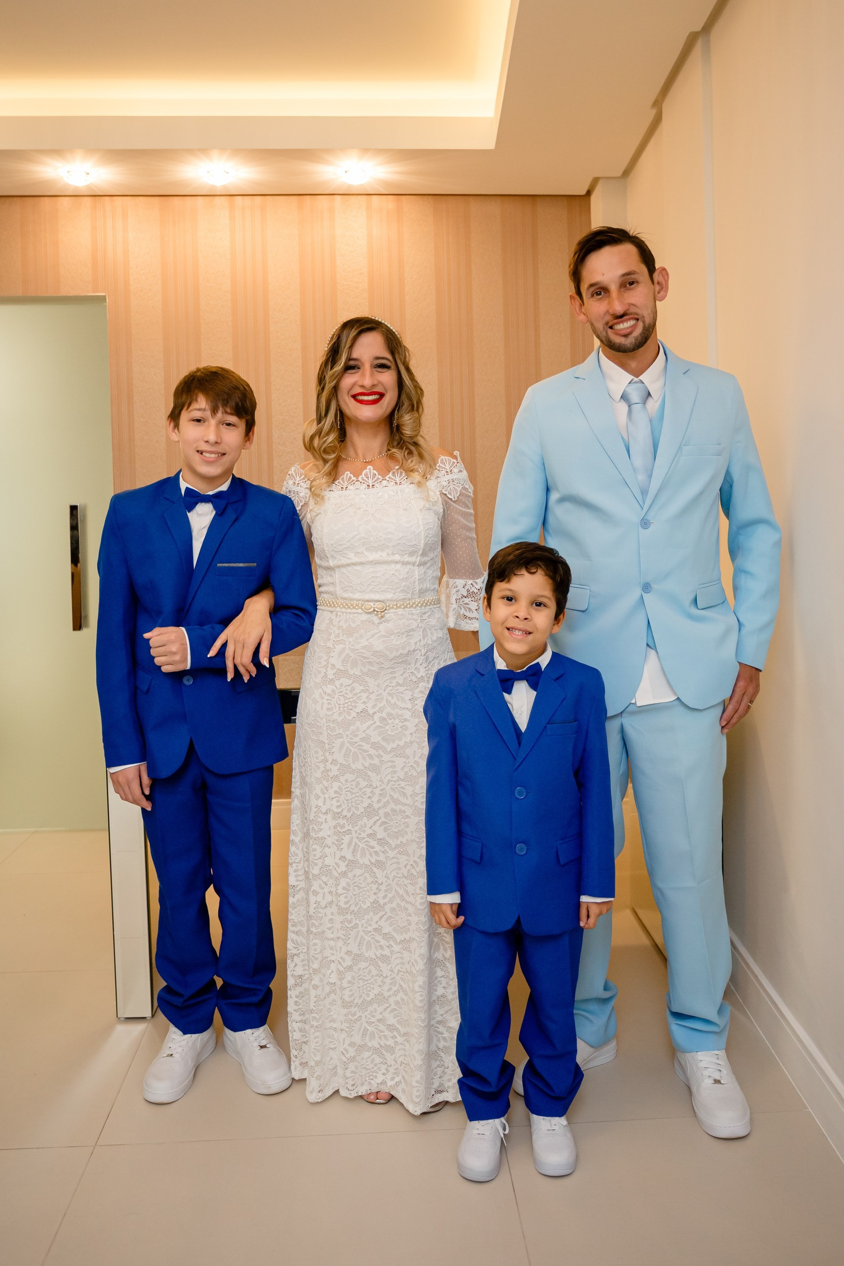 Fotógrafo de casamento civil em Navegantes; retrato de família completo reunindo os noivos e dois pajens de terno azul após a cerimônia no cartório.