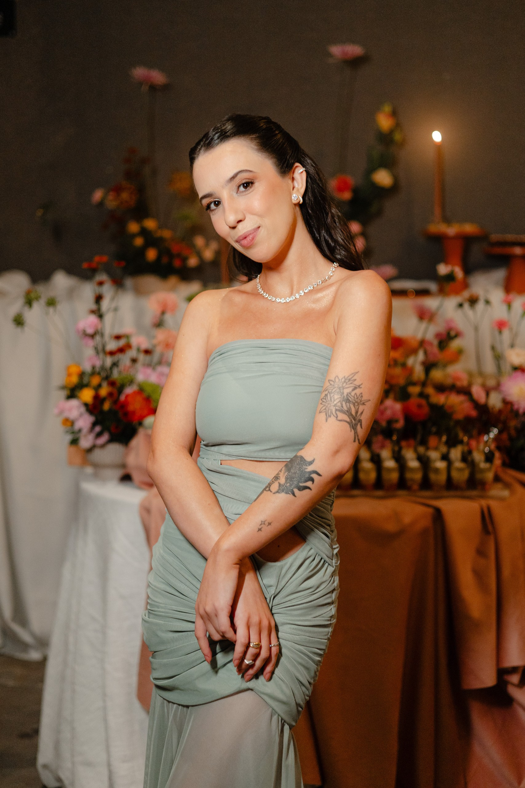 Formanda olhando para a câmera com mesa de doces ao fundo.