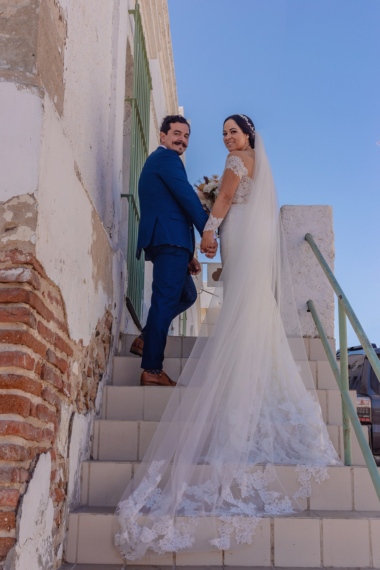 Bride and groom walking upstairs in historic downtown San José del Cabo during wedding session