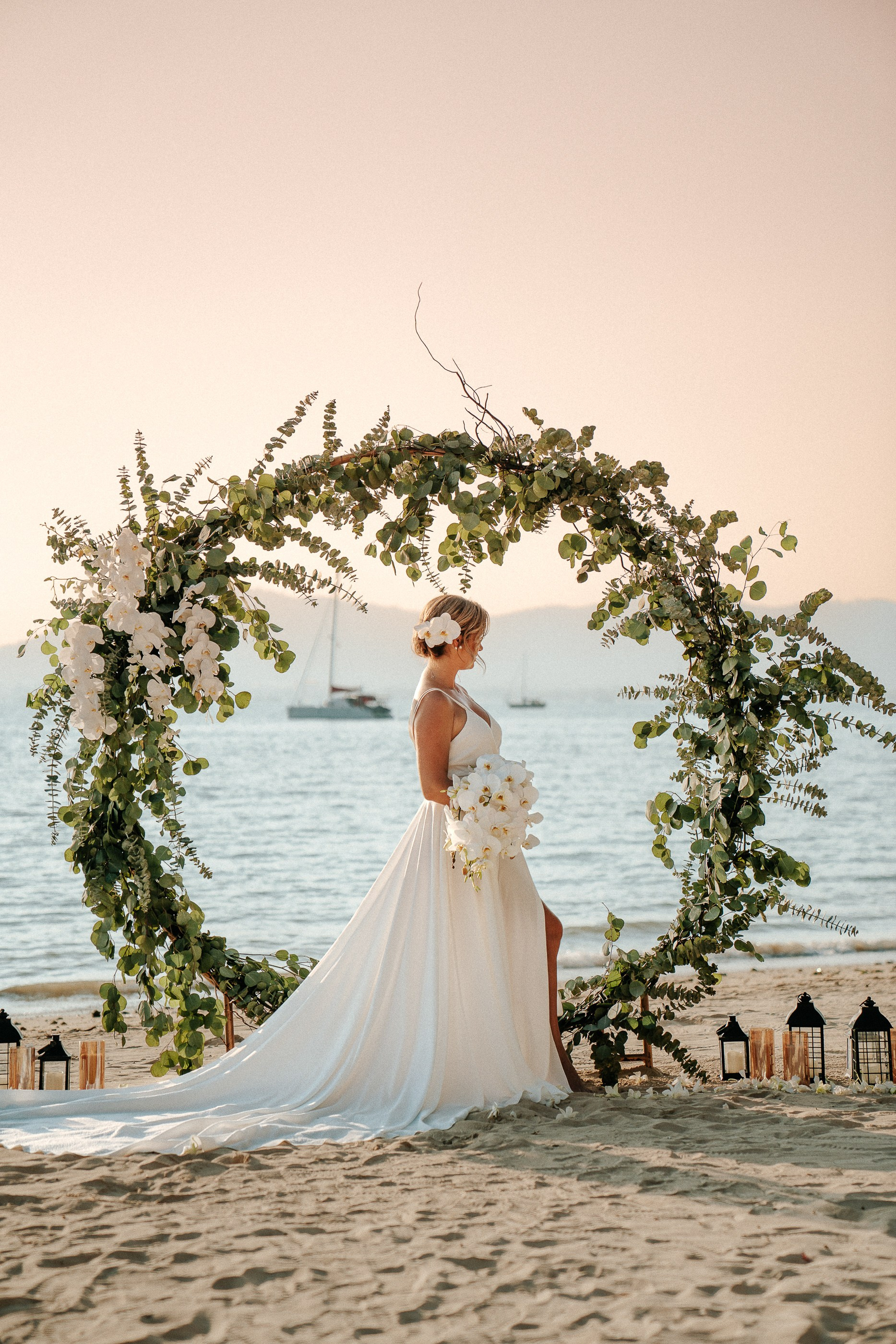Luxury wedding photography in Phuket featuring a bride and arch on a tropical beach