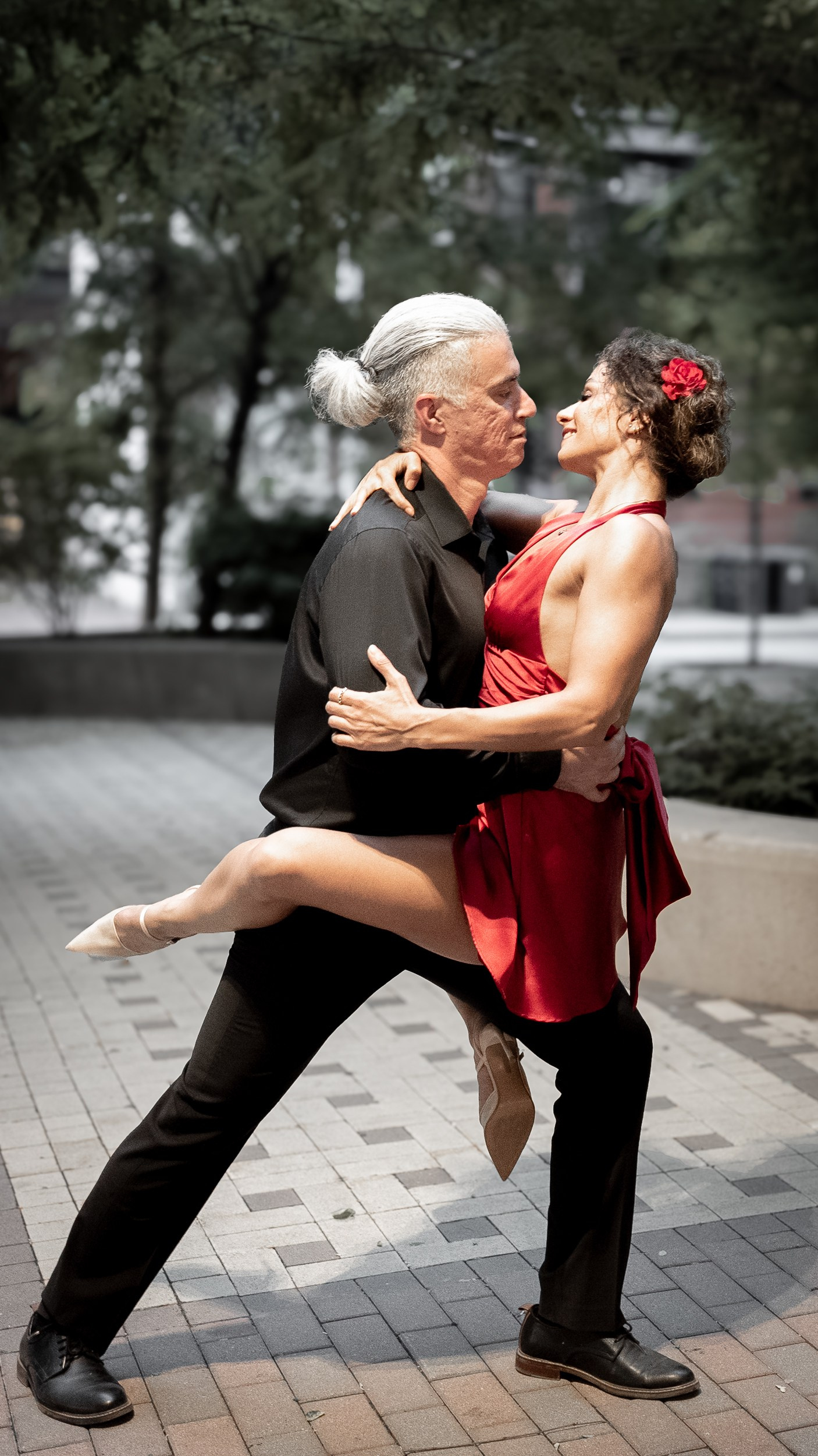 Couple dancing on a quiet street under string lights — celebrating their upcoming wedding