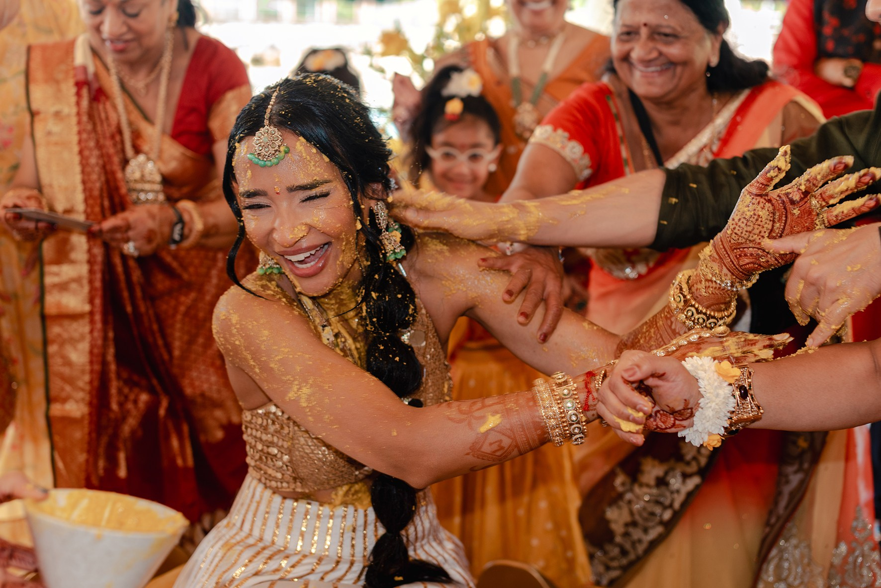 Indian bride covered in turmeric during Haldi ceremony at a destination wedding in Cancun, Mexico