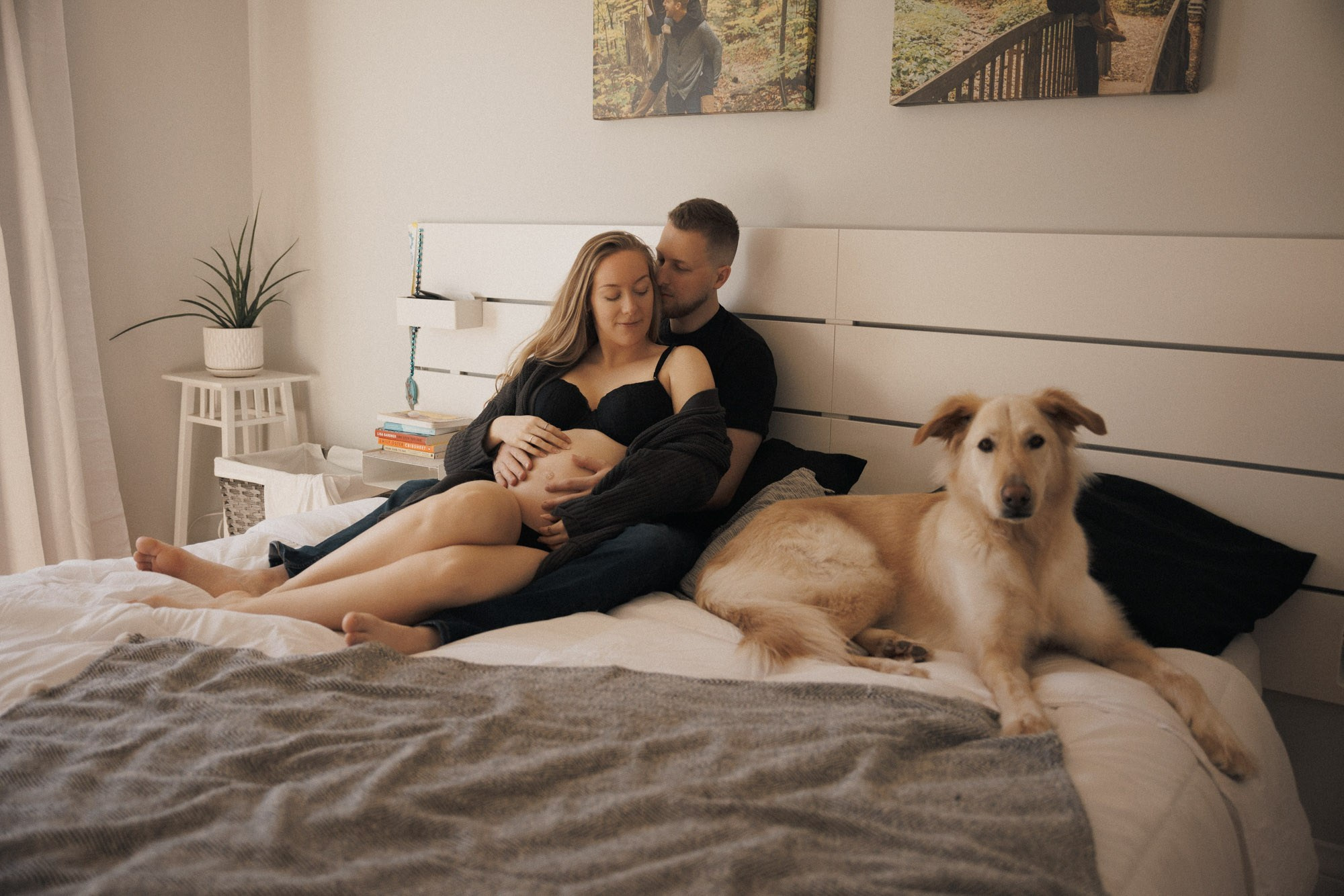 Expecting couple relaxing at home with their dog during a maternity session in Montreal