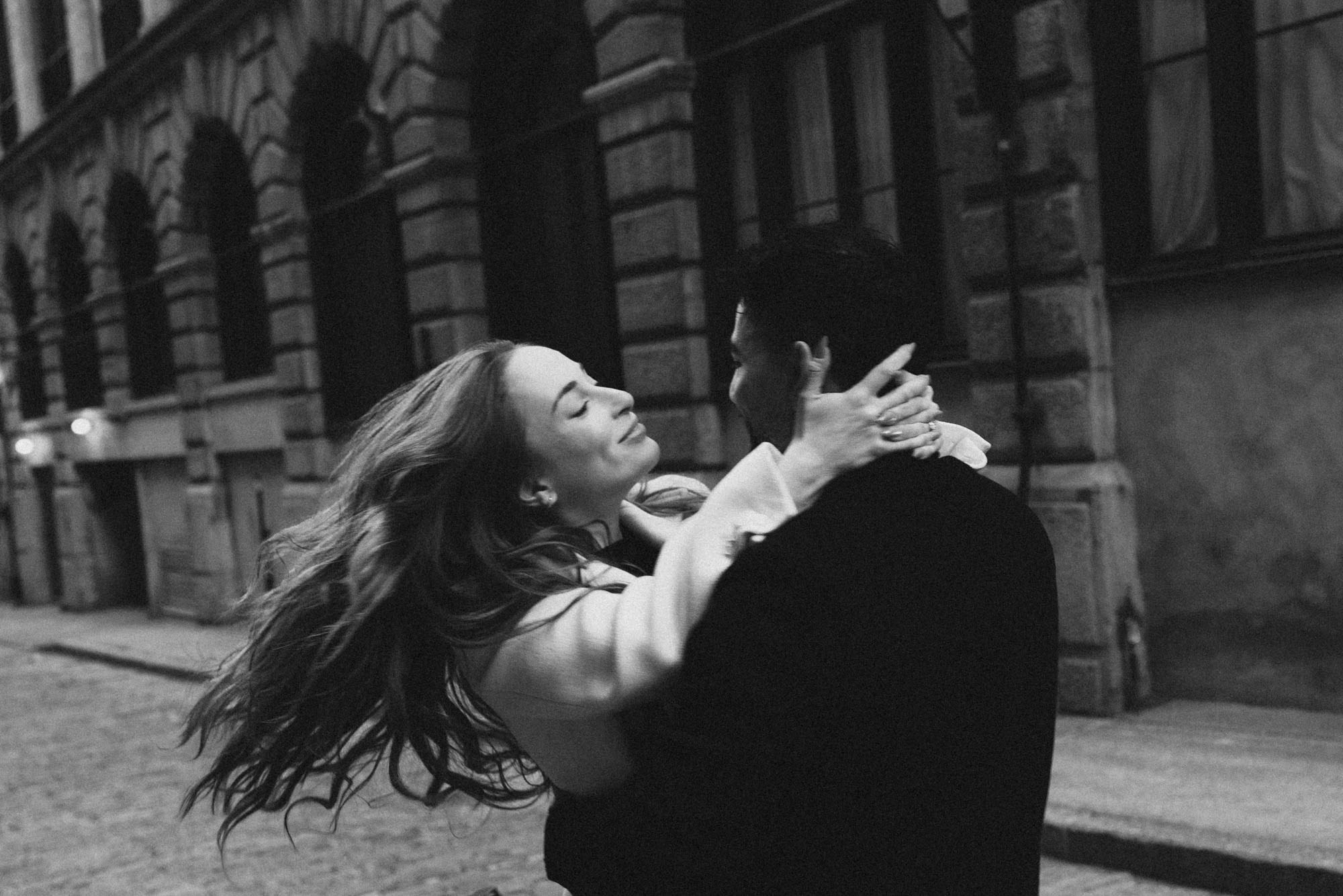 Couple laughing and embracing on a cobblestone street in Old Montreal
