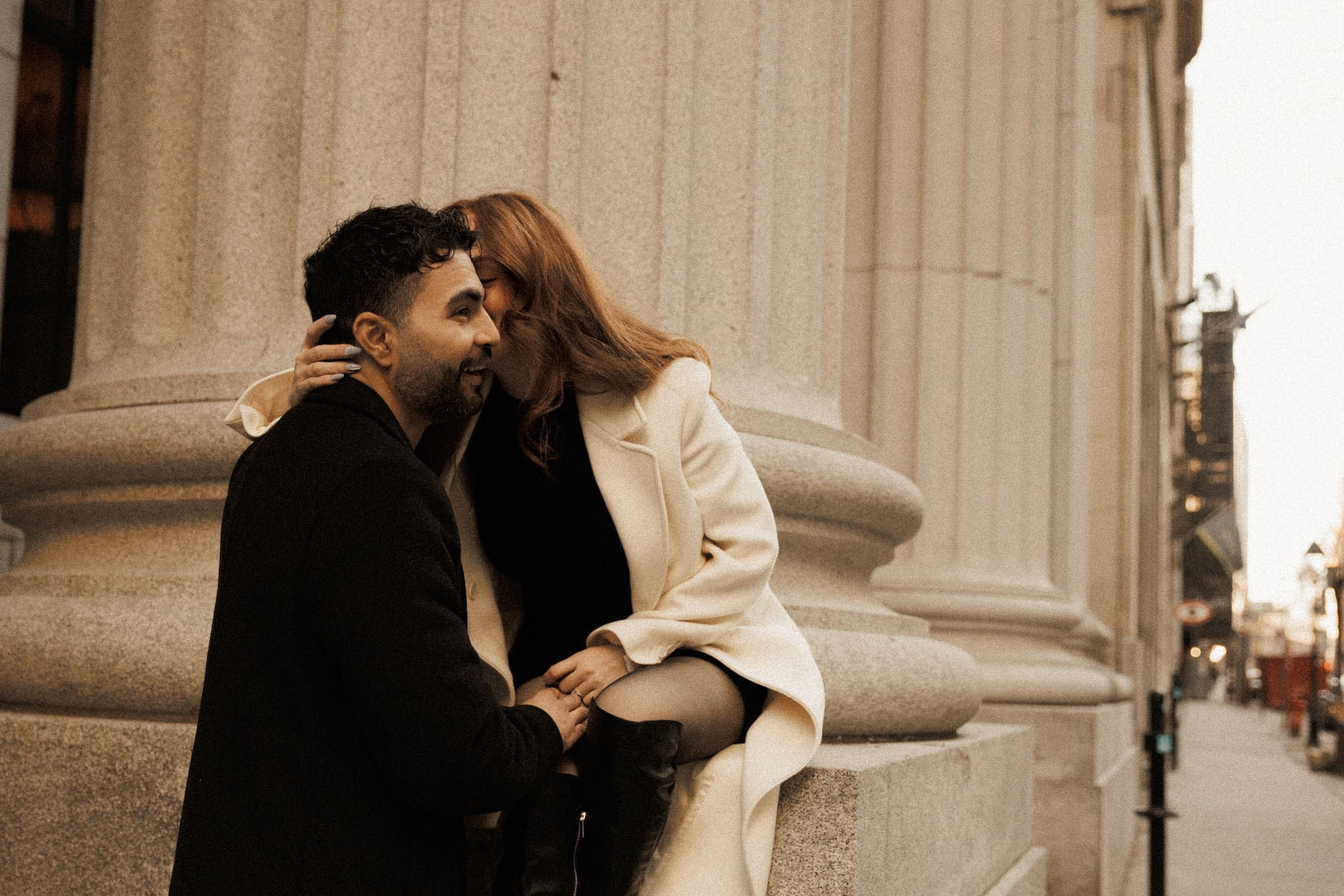 Couple sharing a quiet kiss beside the stone columns of an Old Montreal building