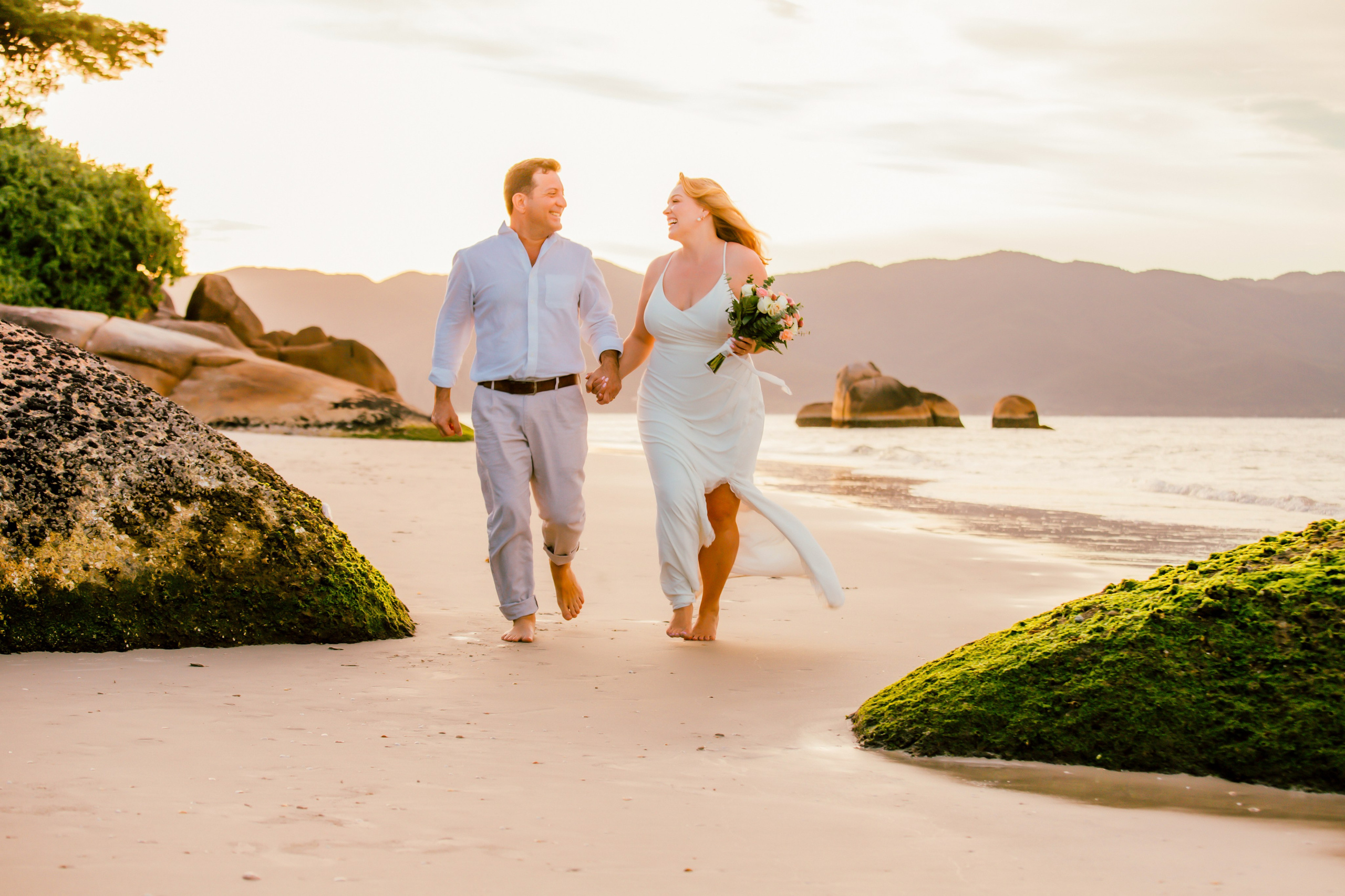Noivos recem casados na praia do forte no fim de tarde em Florianópolis