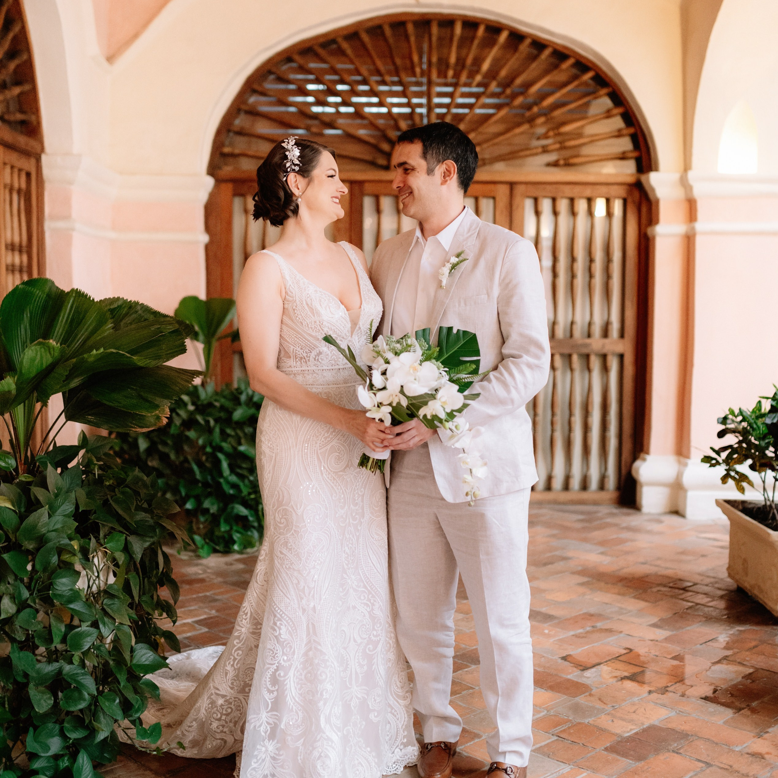 ride and groom outdoor portrait – “Bride and groom embracing outdoors in an elegant courtyard, high-quality wedding photography in Cartagena”