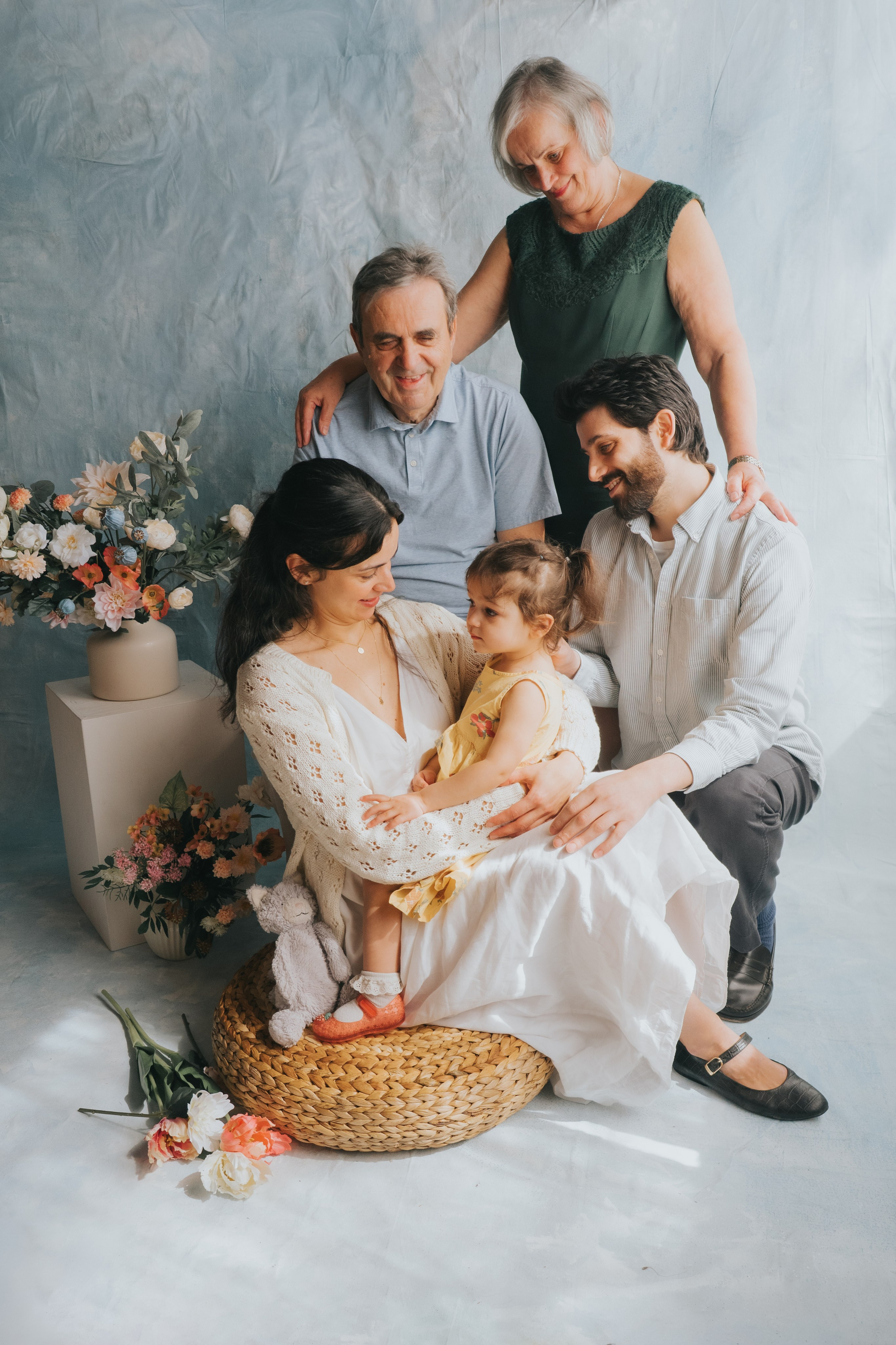 Candid documentary family photo of grandparents, parents and grandchild laughing together, Montreal family photographer