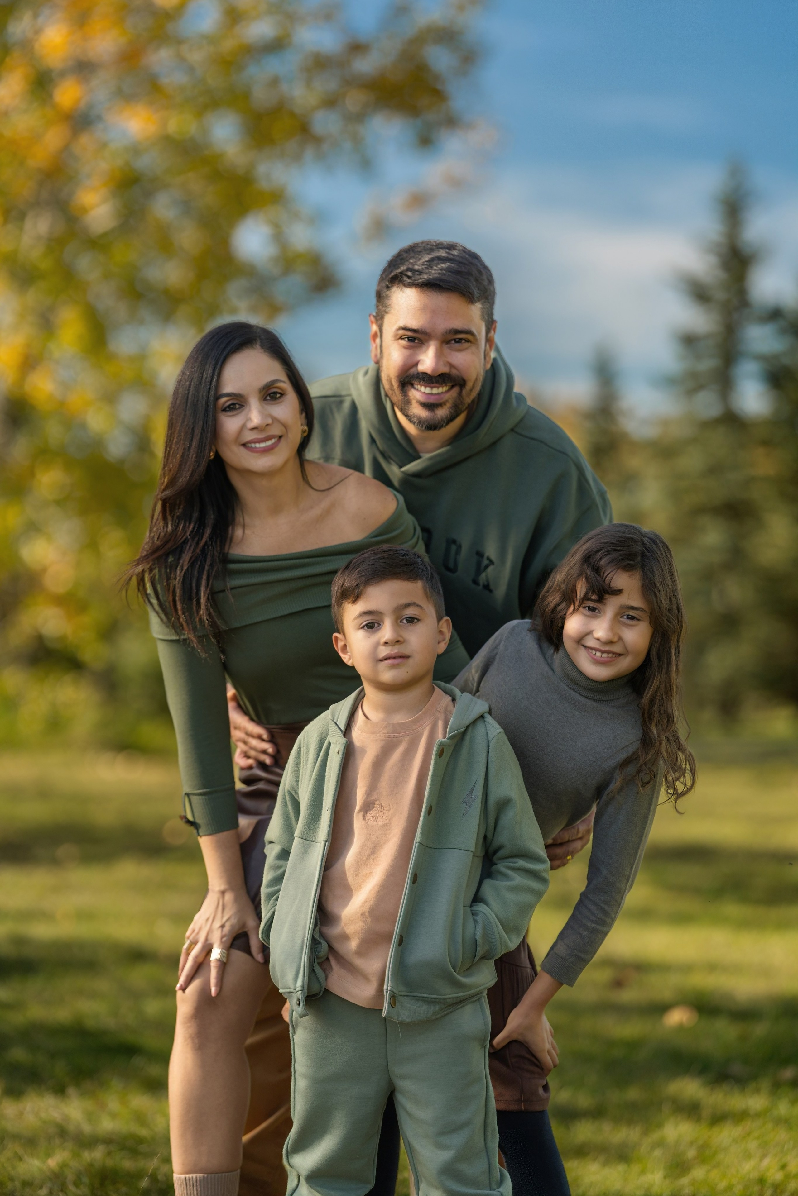 Fall family mini session in Calgary with kids and parents among yellow autumn trees
