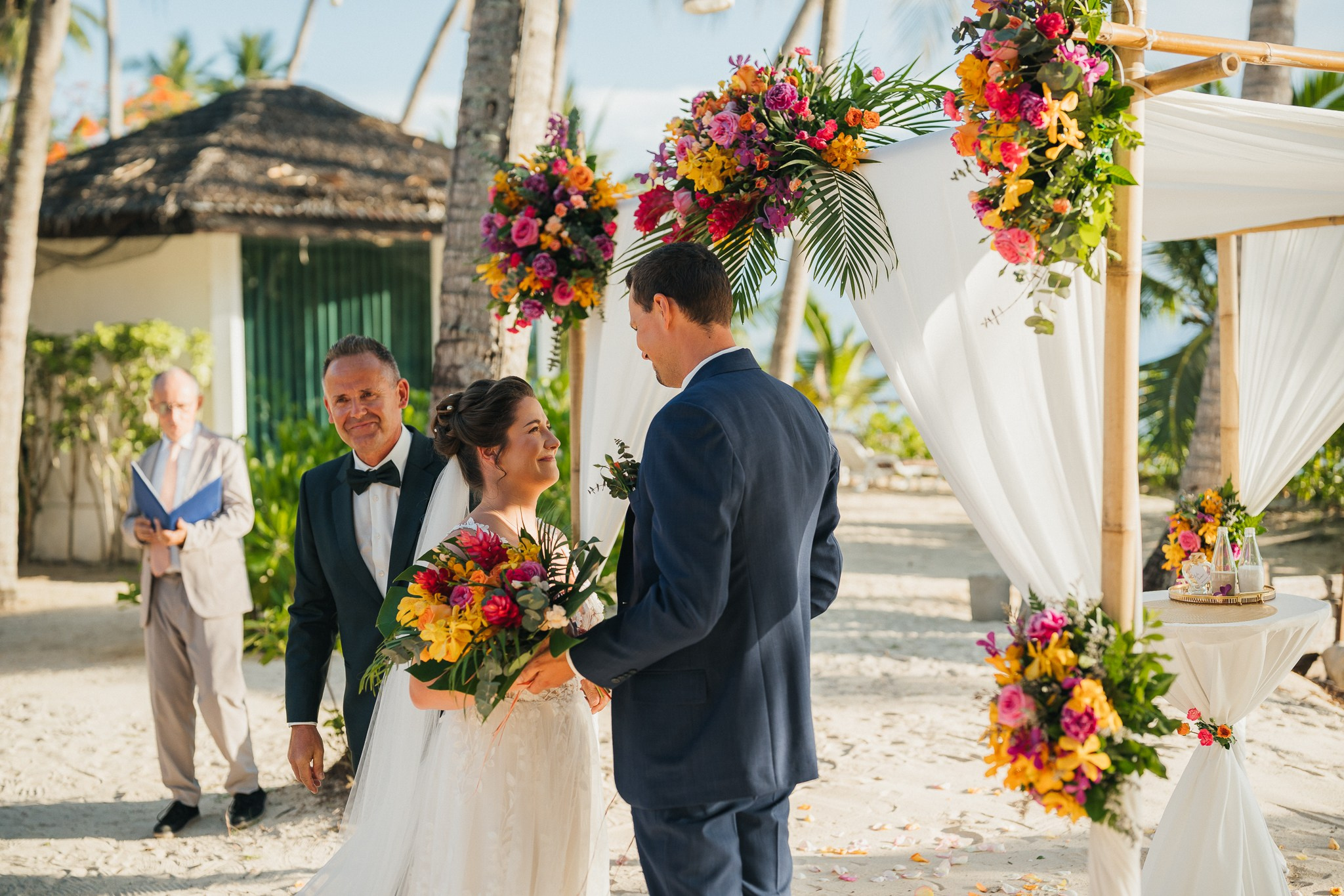Destination beach wedding in Koh Samui, Thailand with the couple, family members and friends enjoying a tropical wedding ceremony by the sea