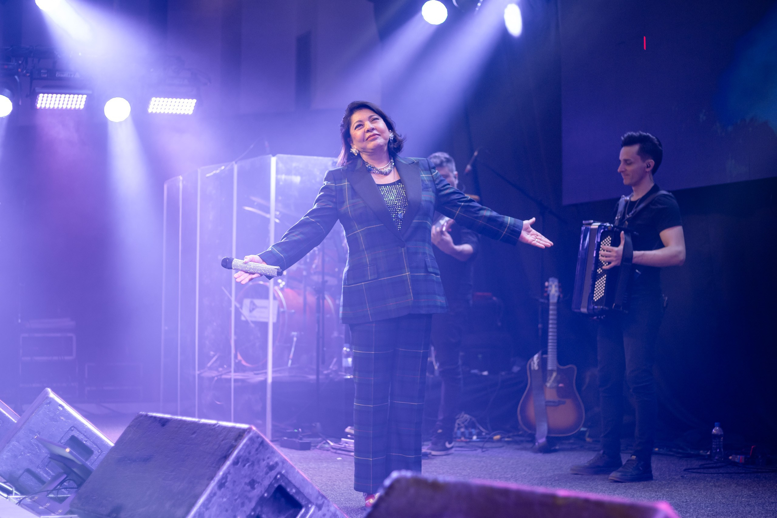 Show musical com cantora fazendo performance no palco.
