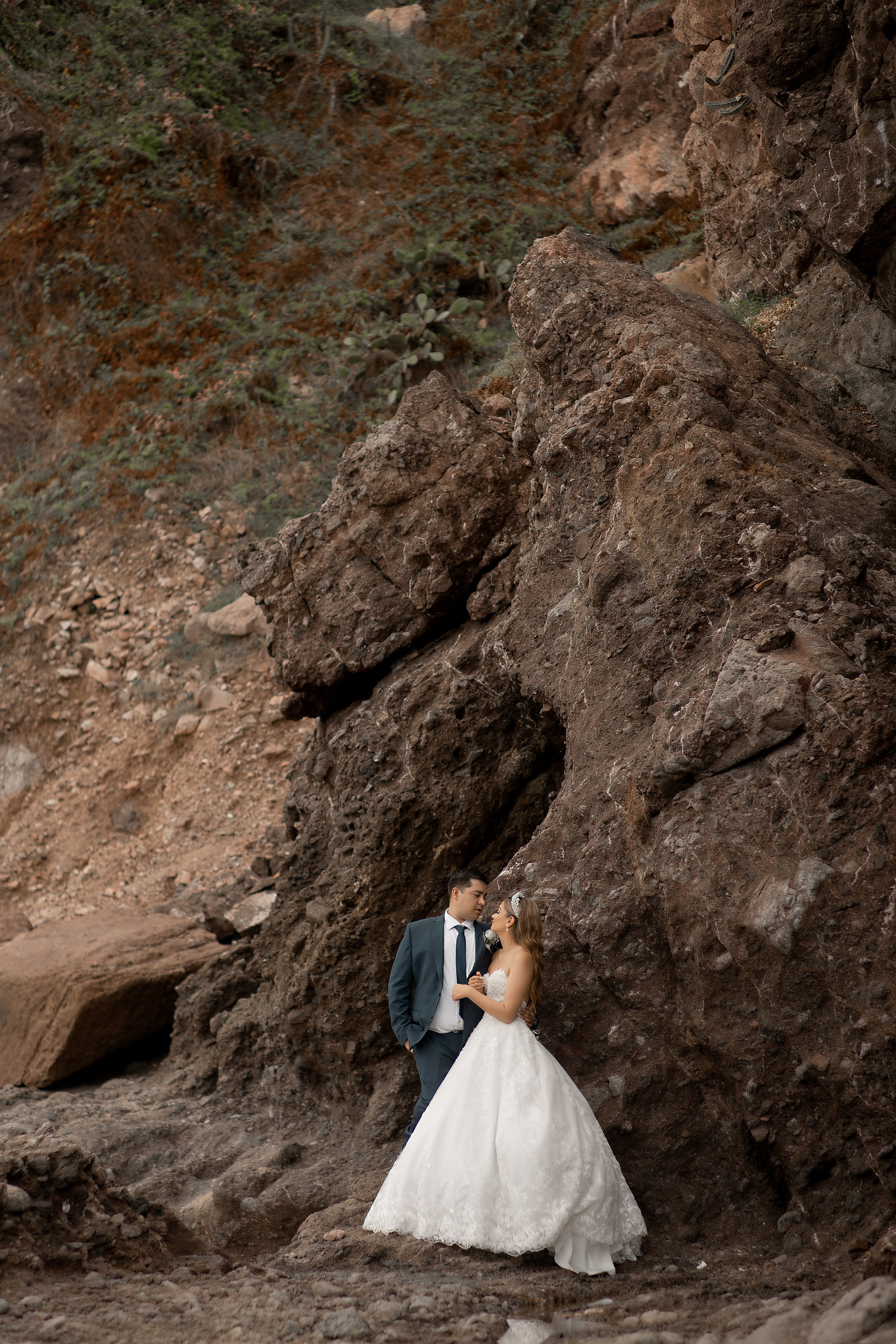 Los novios al lado de una roca
