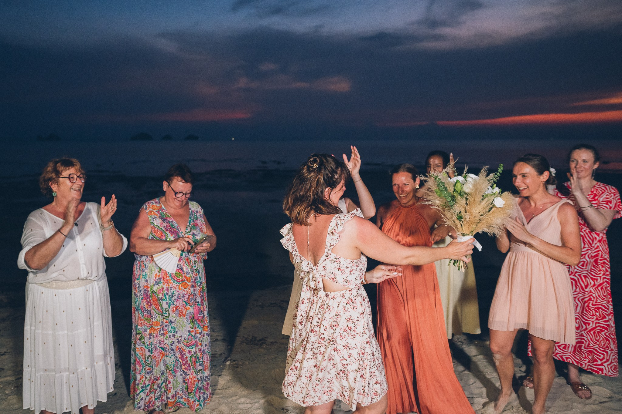 Wedding celebration with guests on a tropical sunset beach in Koh Samui
