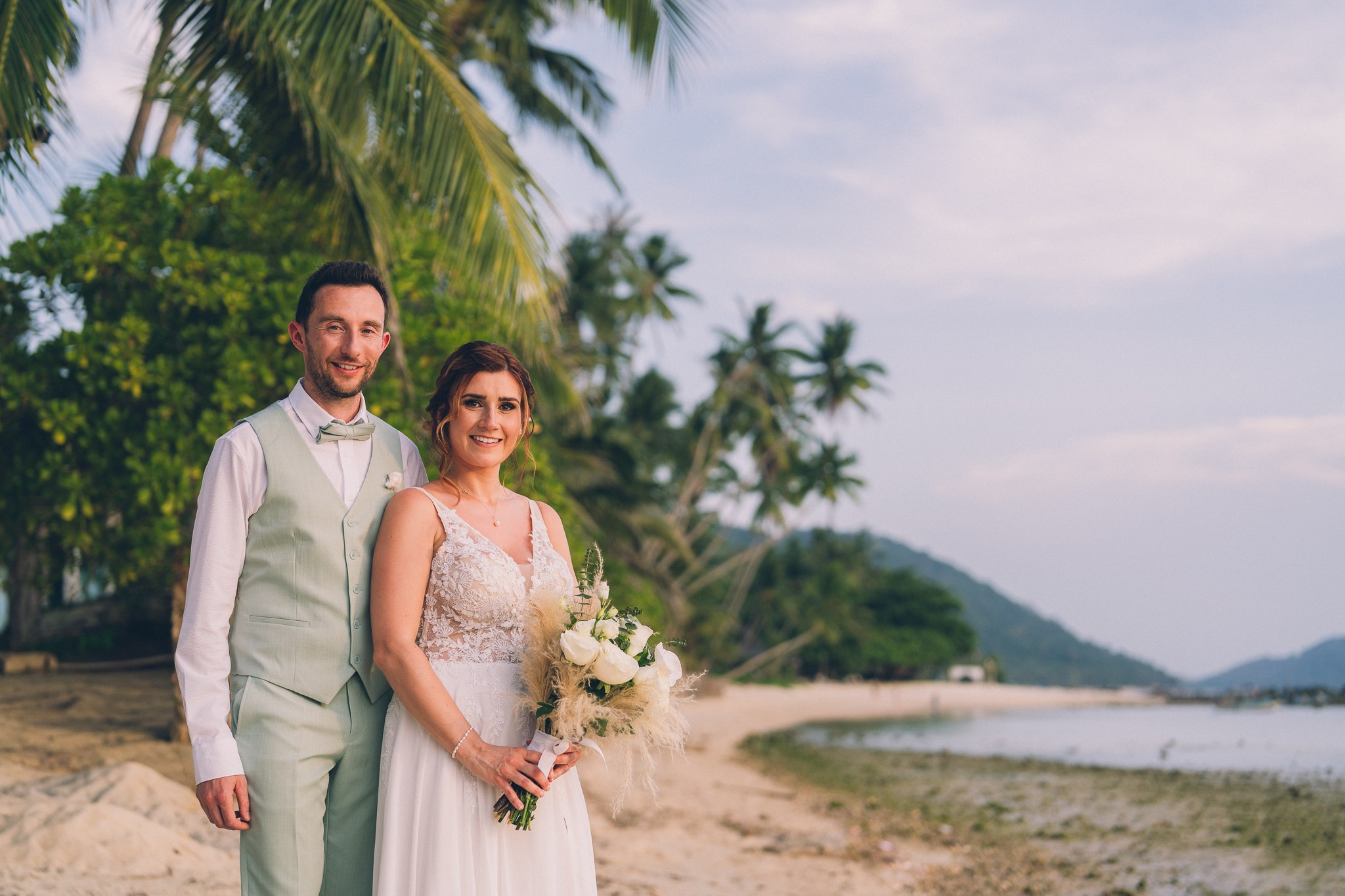 Wedding celebration with guests on a tropical sunset beach in Koh Samui