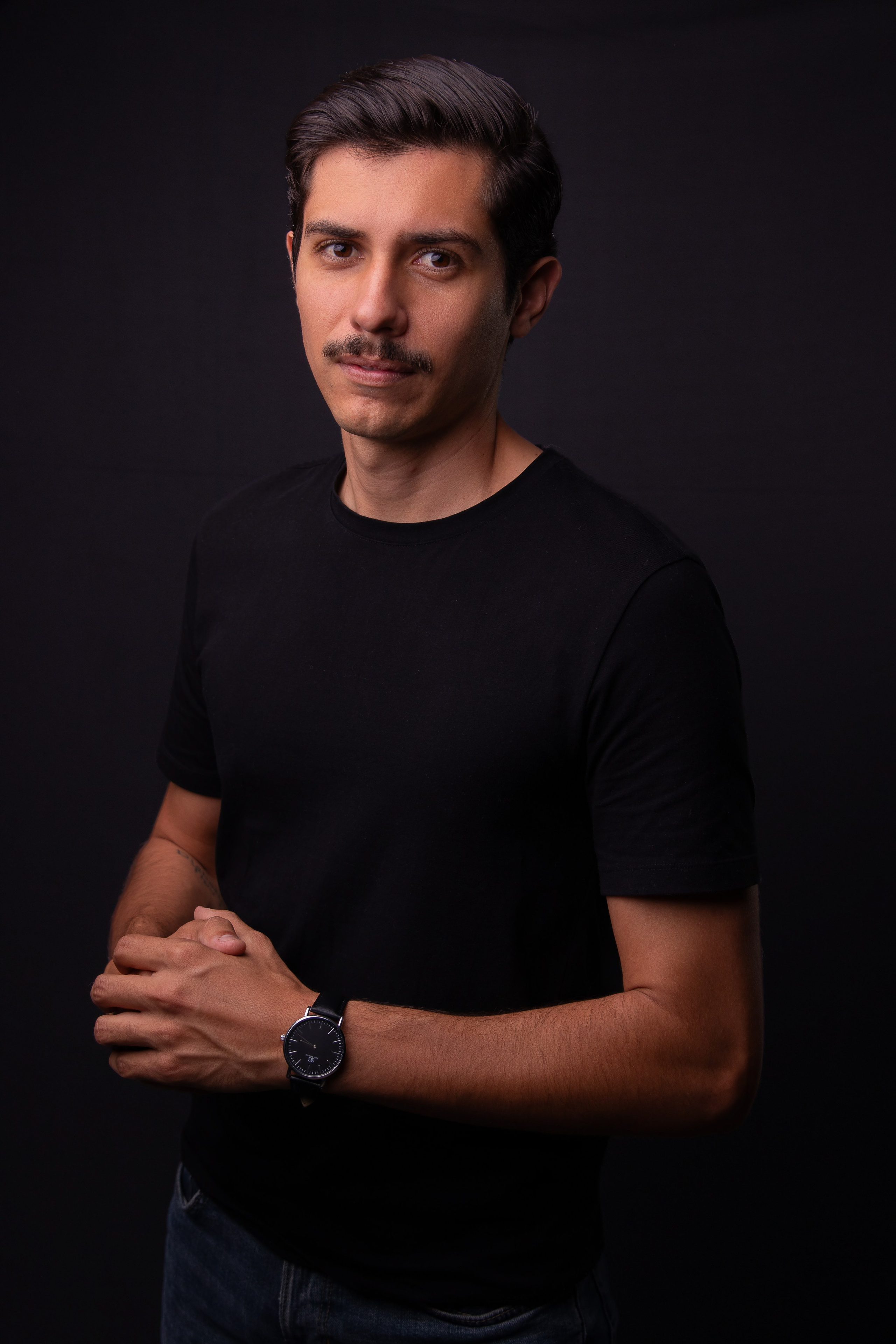 Ensaio de foto corporativa em estúdio para fisioterapeuta, fundo escuro e iluminação de perfil.
