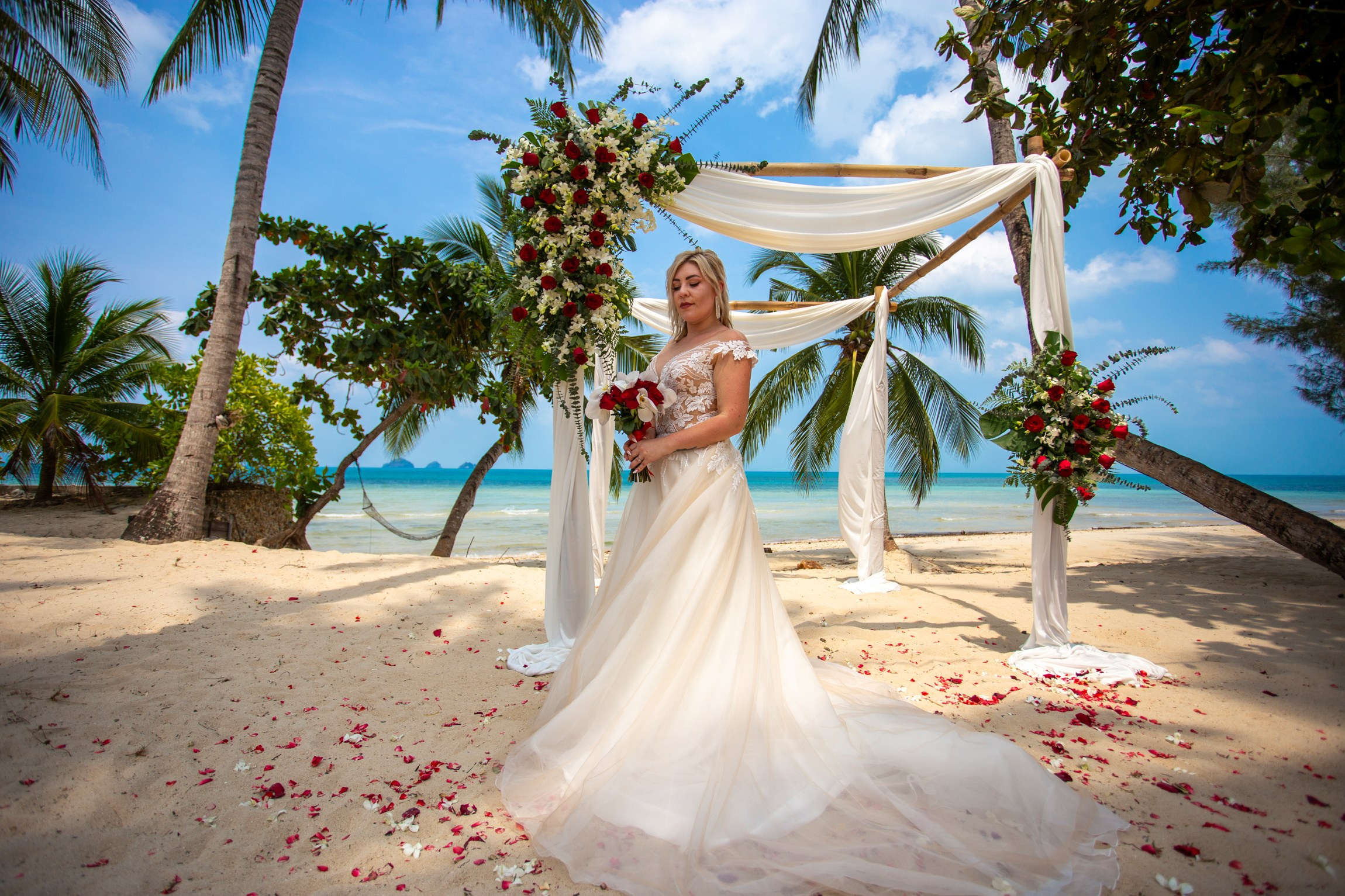 Bride and groom during a romantic beach wedding ceremony on Koh Samui, Thailand, surrounded by tropical scenery and ocean views