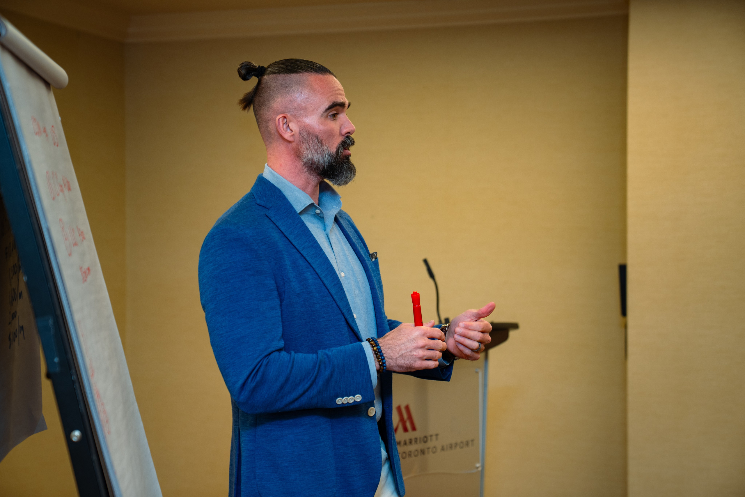 Matt Poechman speaking beside easel at real estate event
