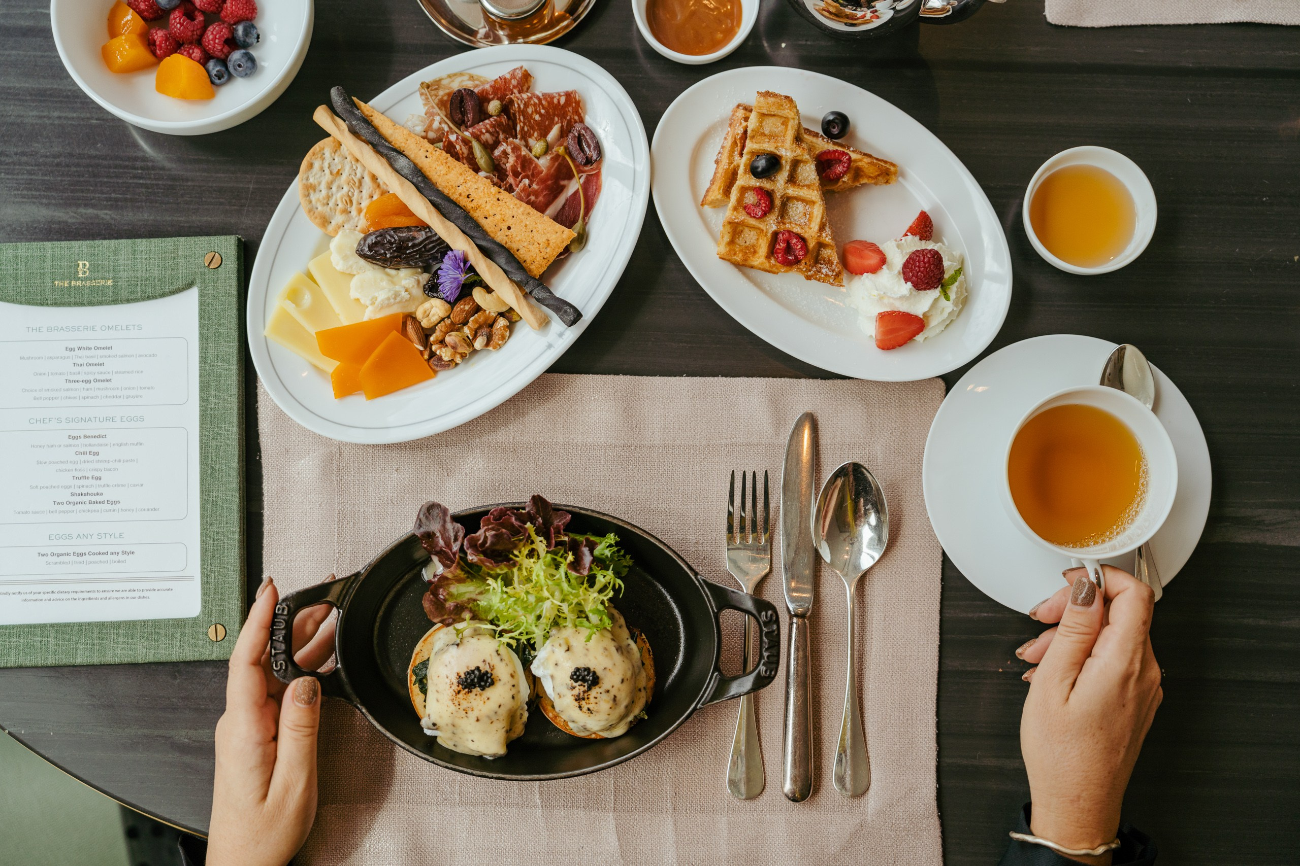 Signature breakfast at Waldorf Astoria Bangkok featuring eggs with caviar, artisan cheese and waffles, styled as an elegant luxury hotel dining experience.