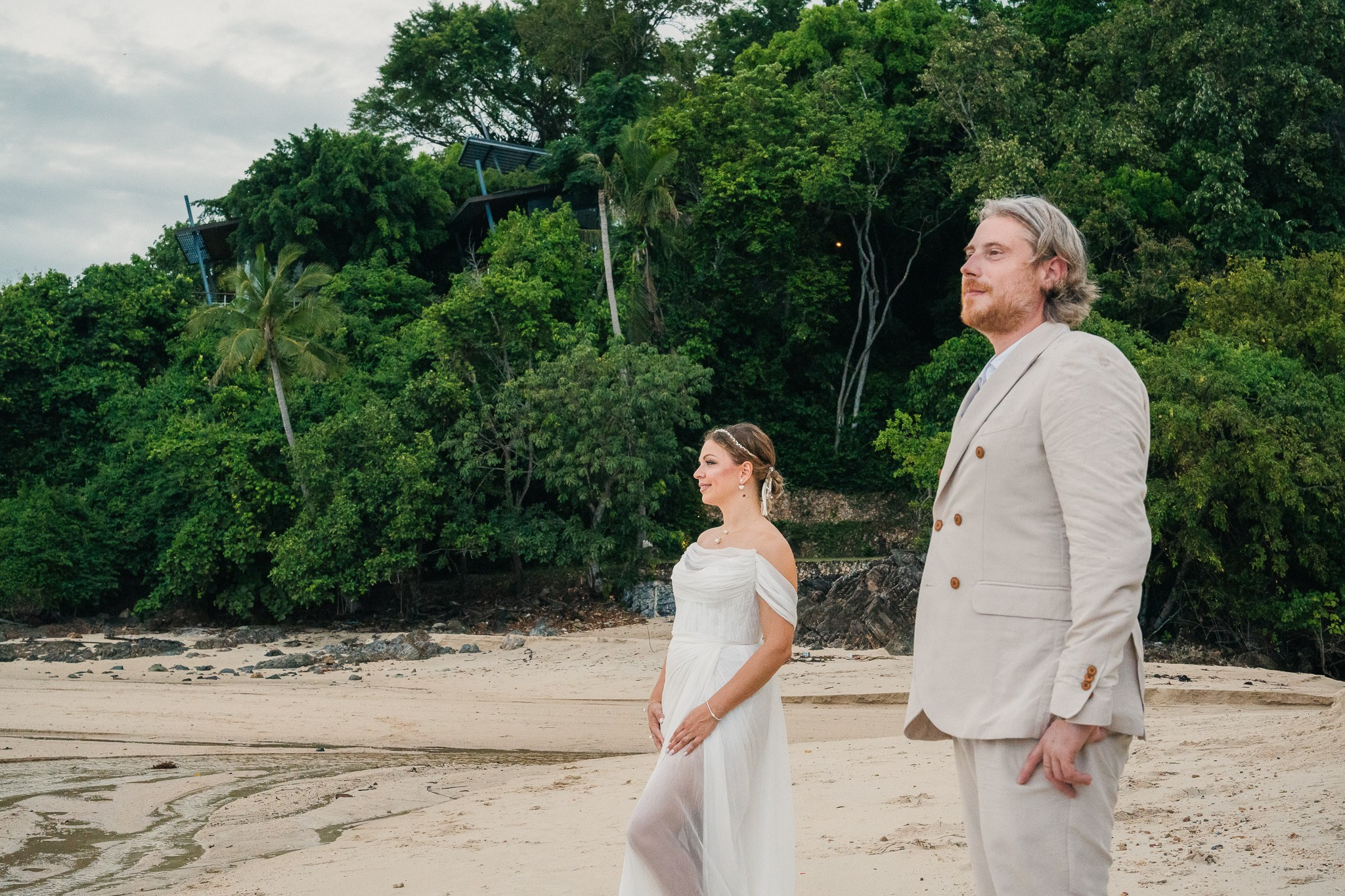 Bride and groom receiving blessings during a Buddhist wedding ceremony on the beach in Koh Samui, Thailand.