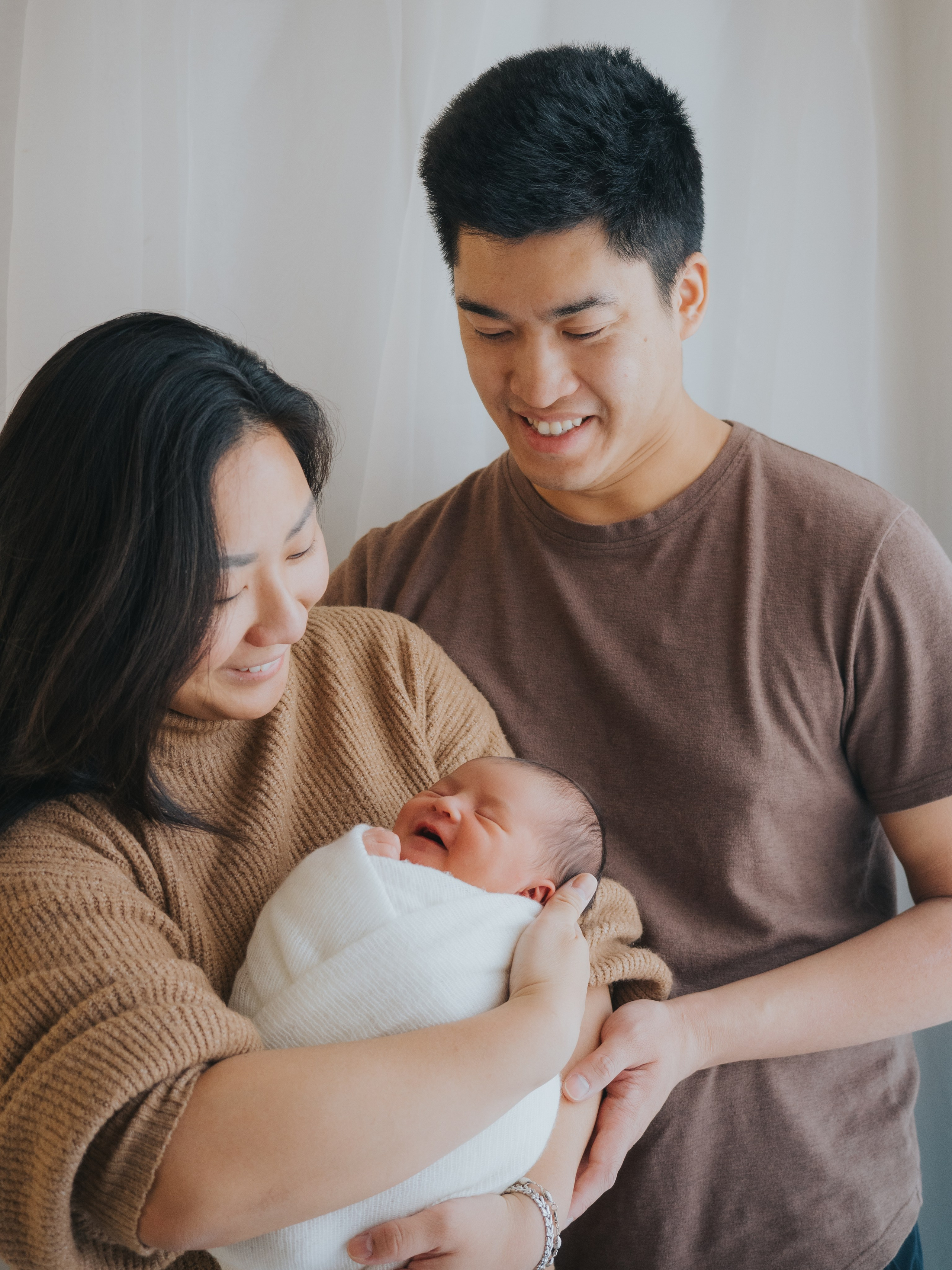 Photo de famille d'une jeune famille, la mère et le père tenant le nouveau-né.