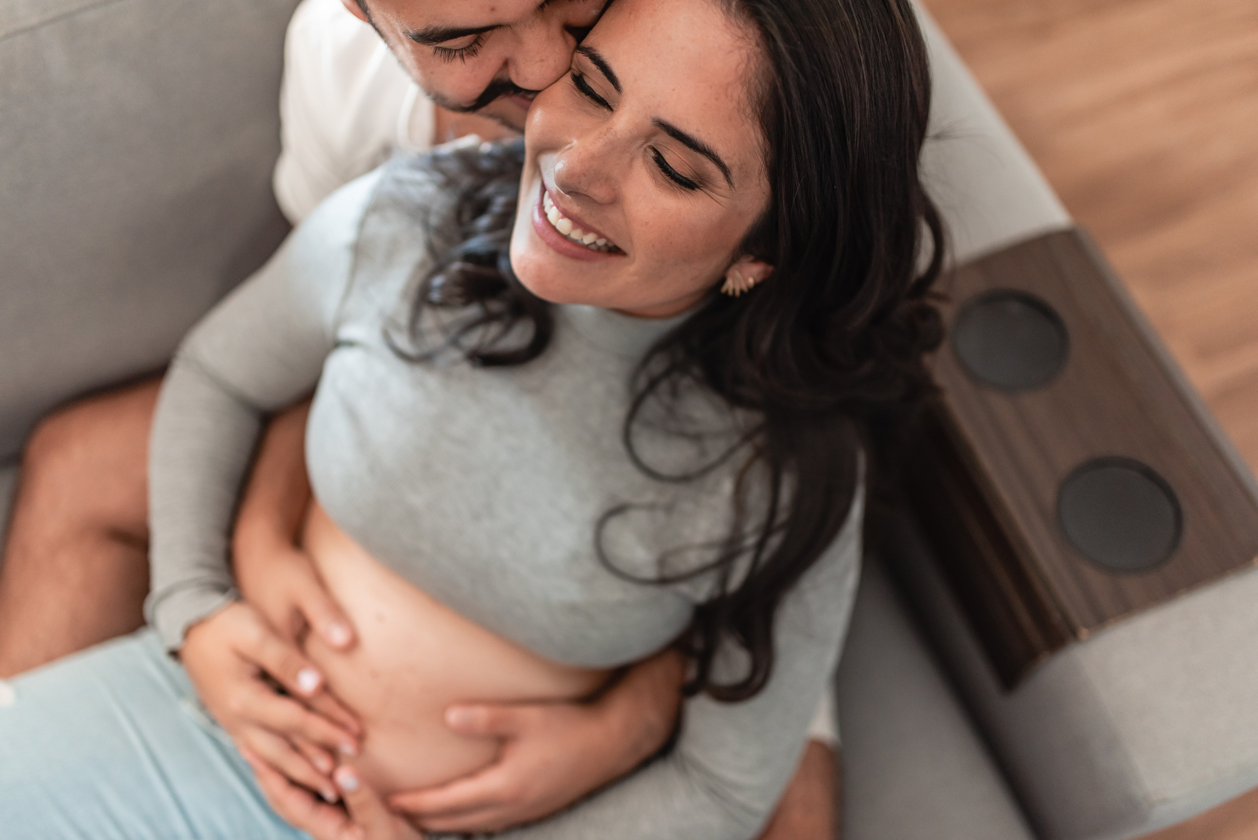 Ensaio gestante lifestyle em casa em Belo Horizonte, casal no sofá com conexão e afeto