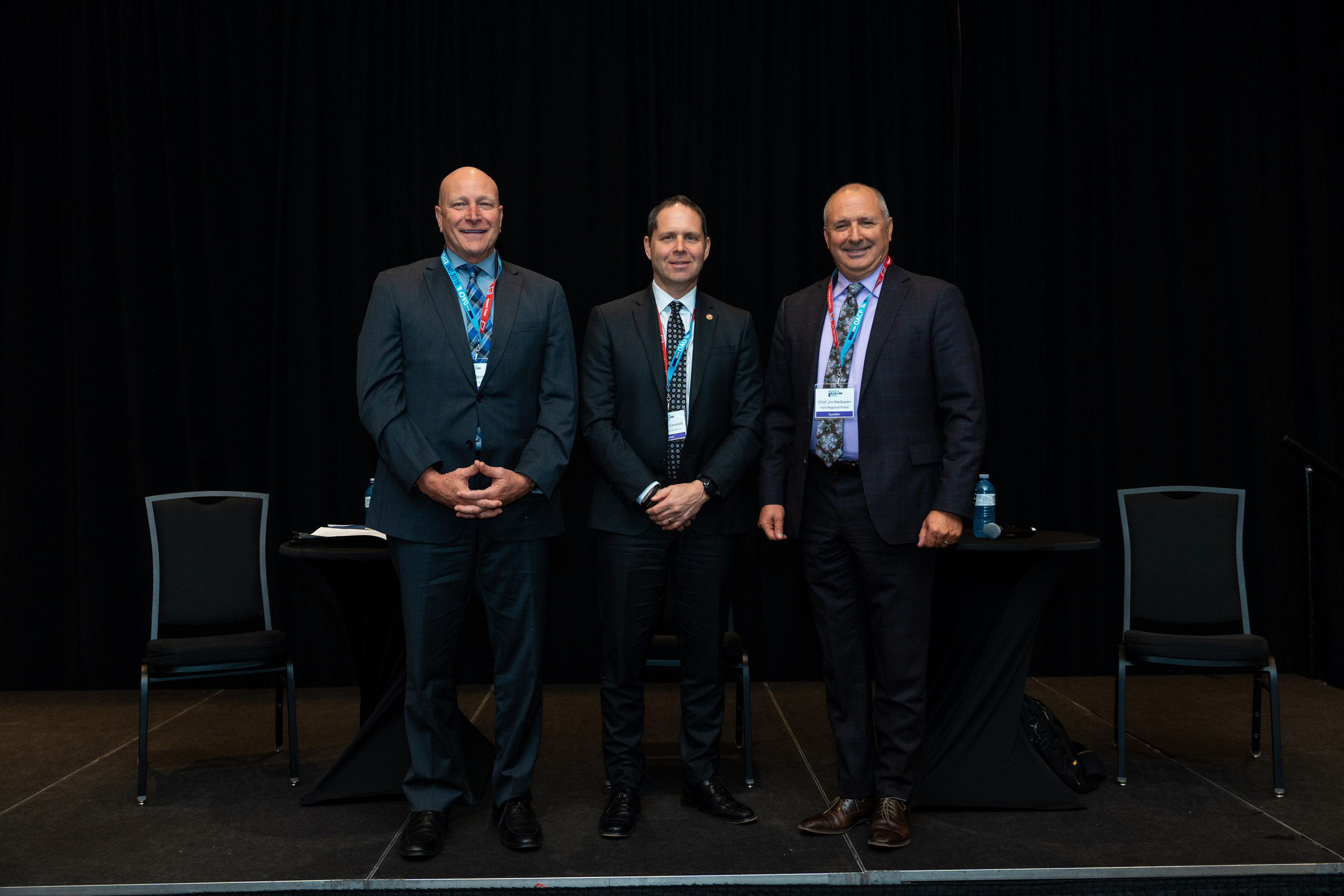 Group of officials in suits posing on stage, Blueline Expo