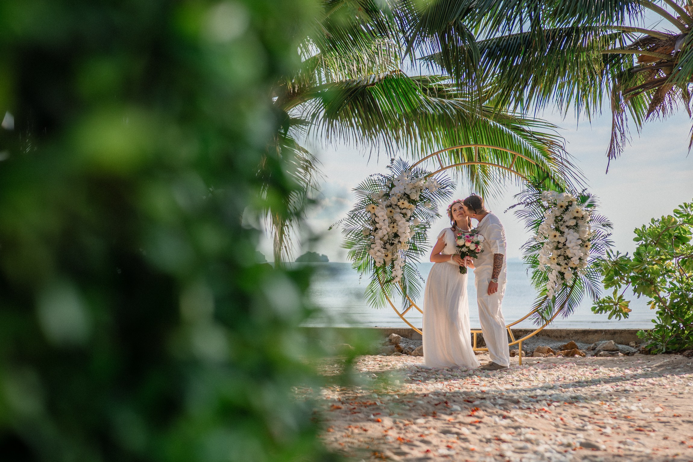 Bride and groom exchanging vows on a private sunset beach
