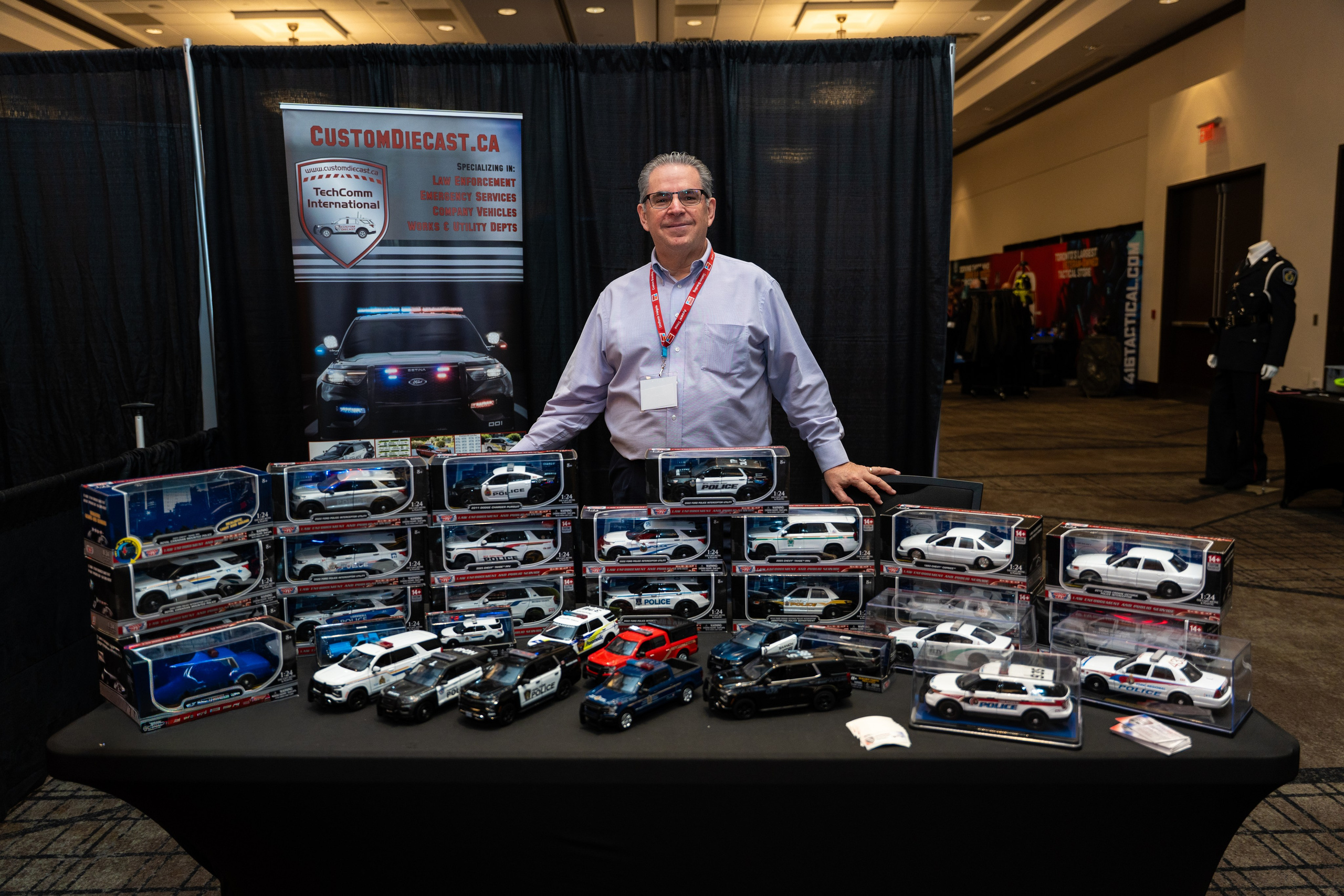 Man reviewing gear at dark exhibitor table, Blueline Expo
